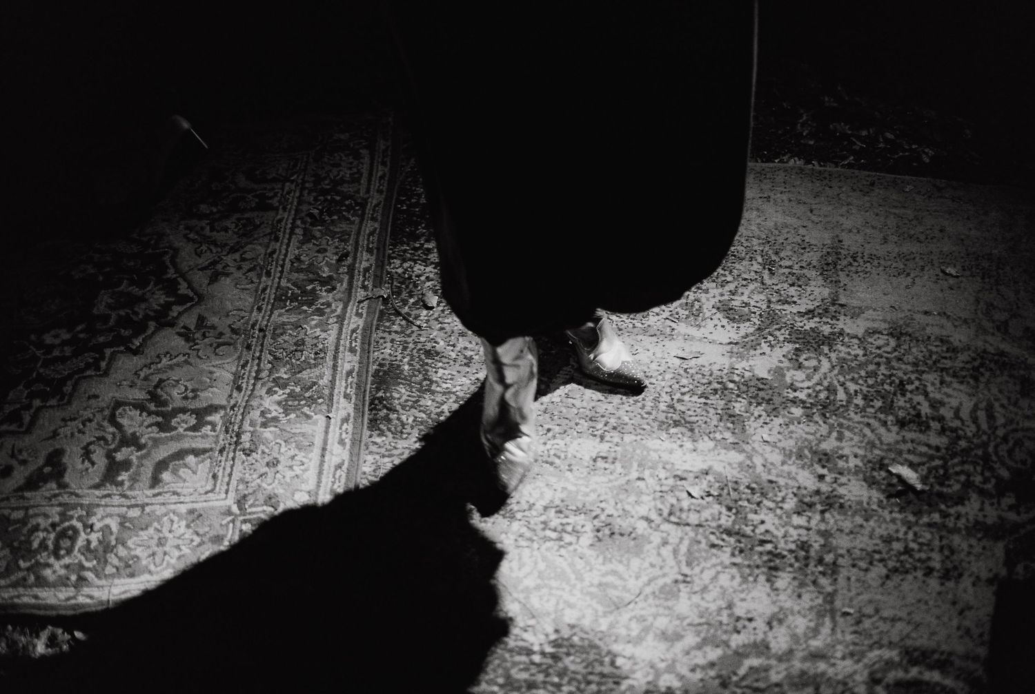 Dark silhouettes cast dramatic shadows against a light textured background.