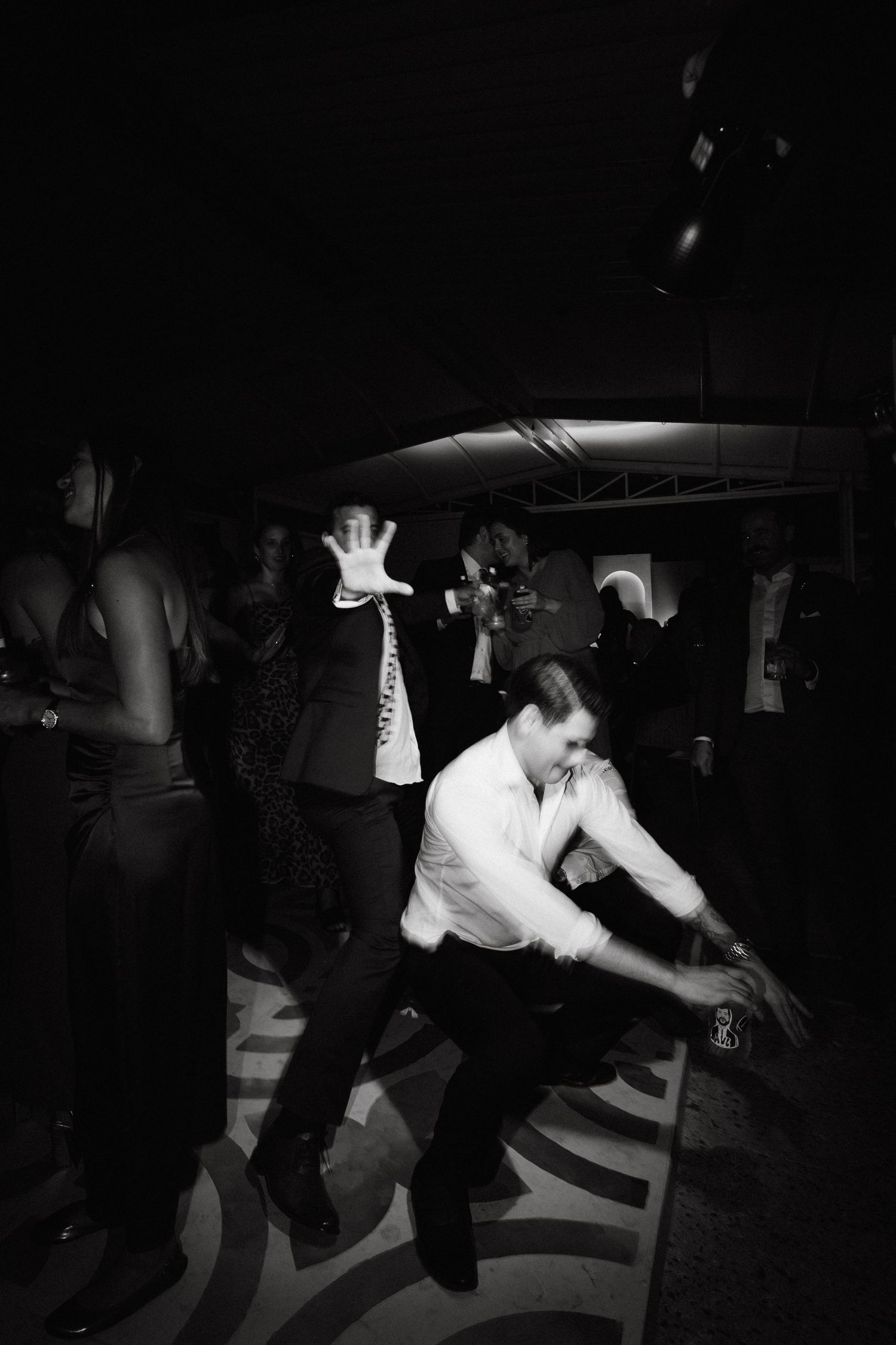 Energetic dance moves captured in black and white at a nighttime event.