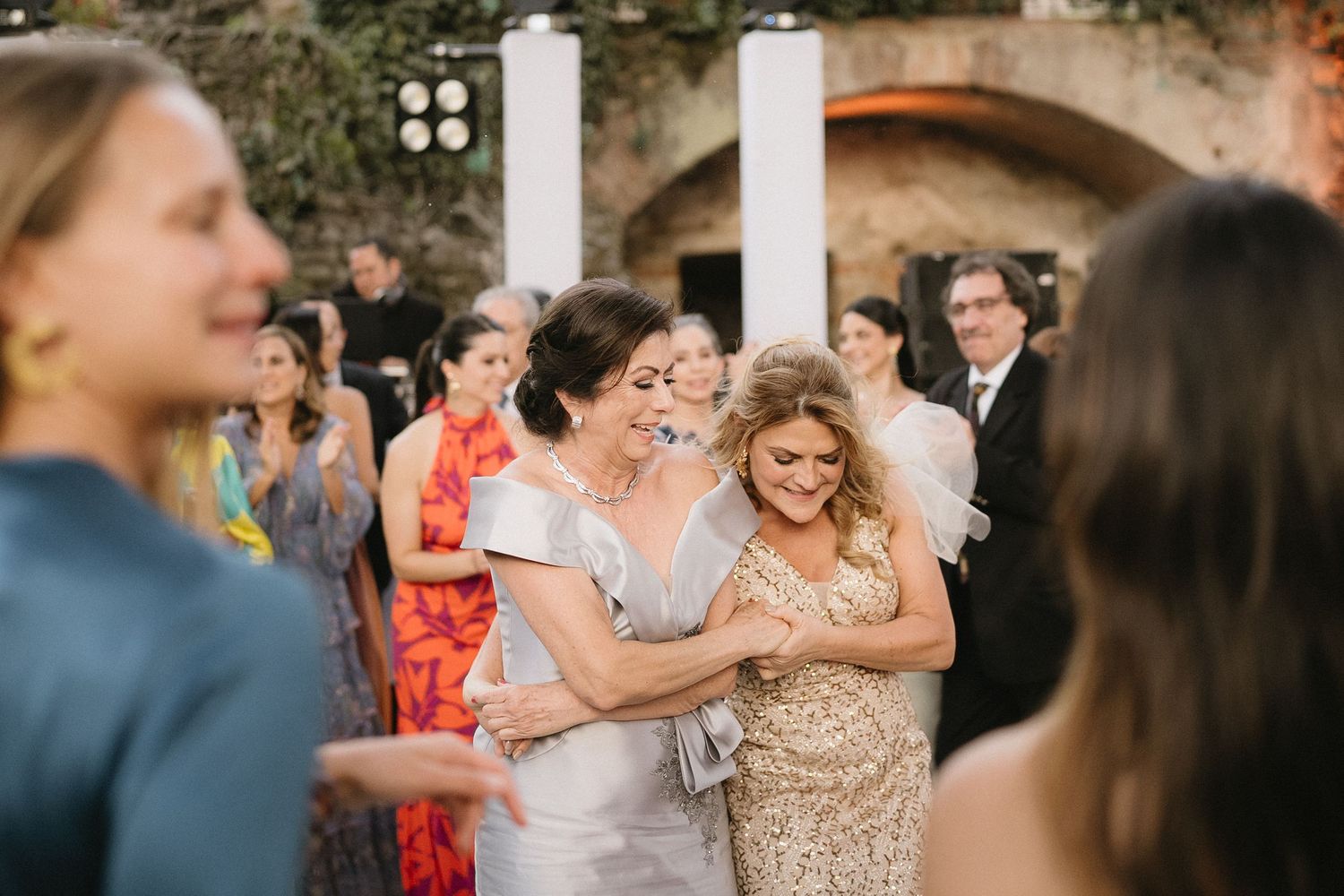 Wedding guests celebrating and dancing together at an outdoor reception.