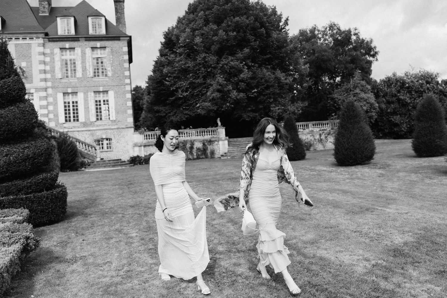 Black and white photos of people running and playing on a grand estate's lawn.
