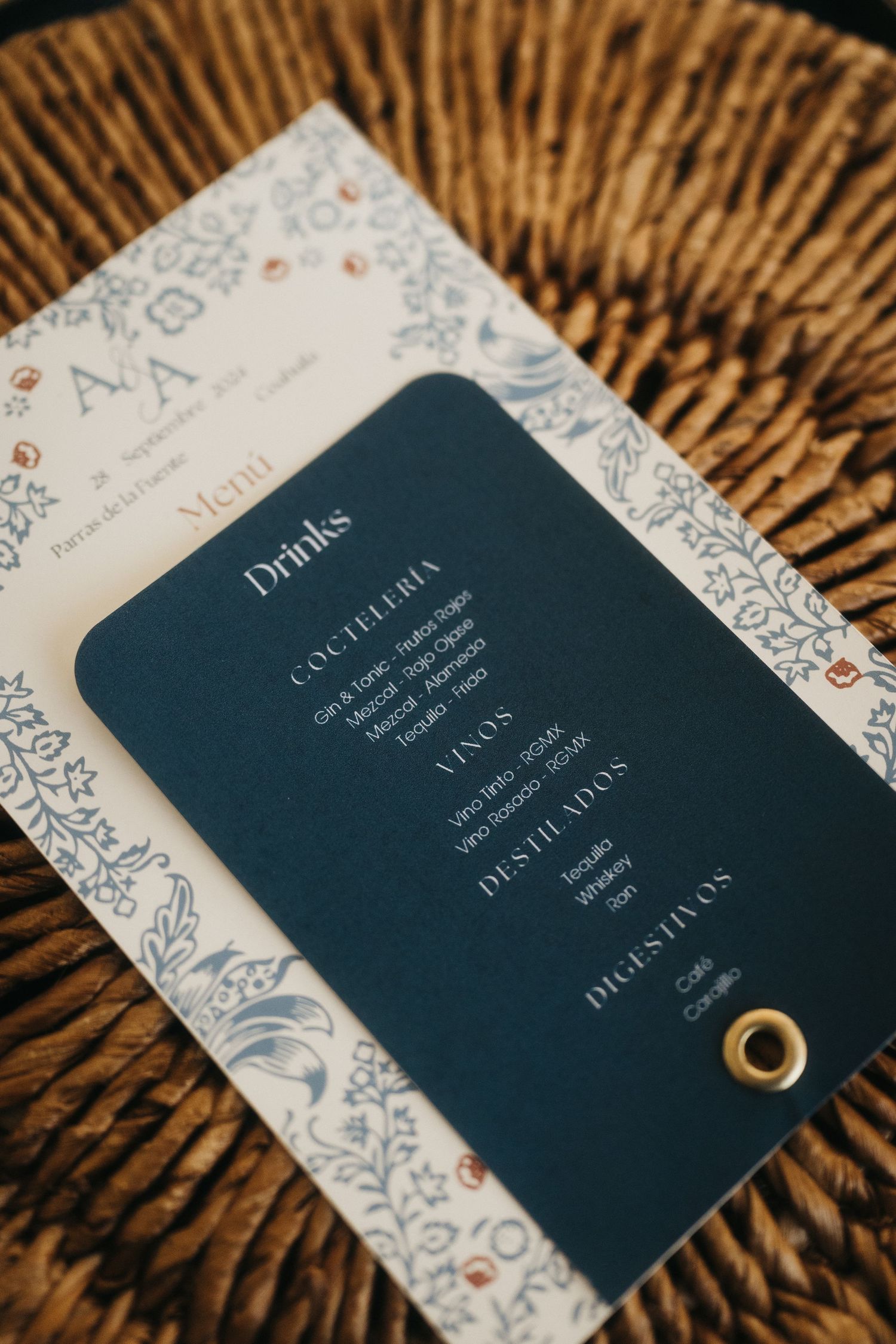 Navy blue and white wedding invitations with elegant design details on woven texture.