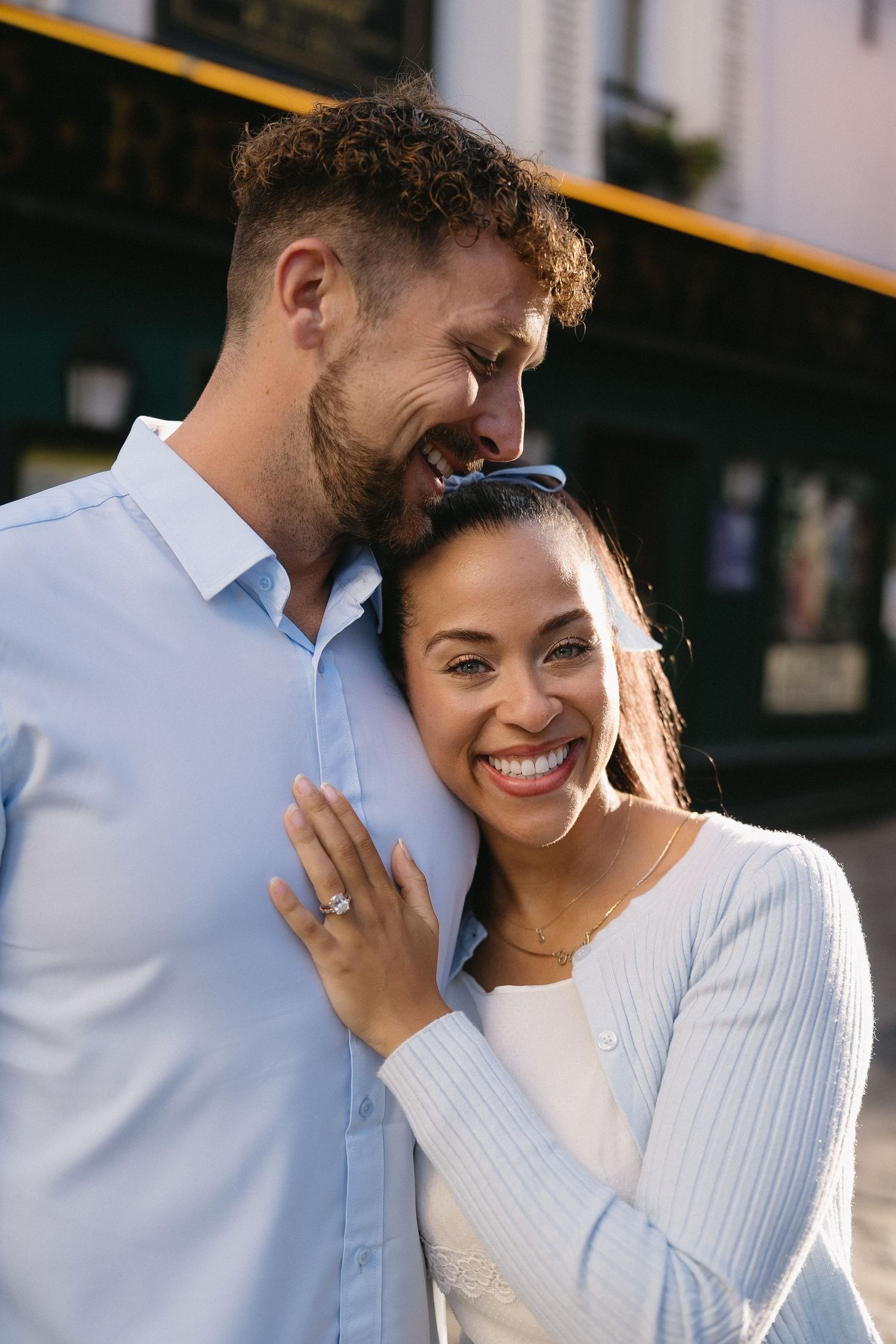 Romantic couple sharing intimate moments while wearing white and embracing in natural light.
