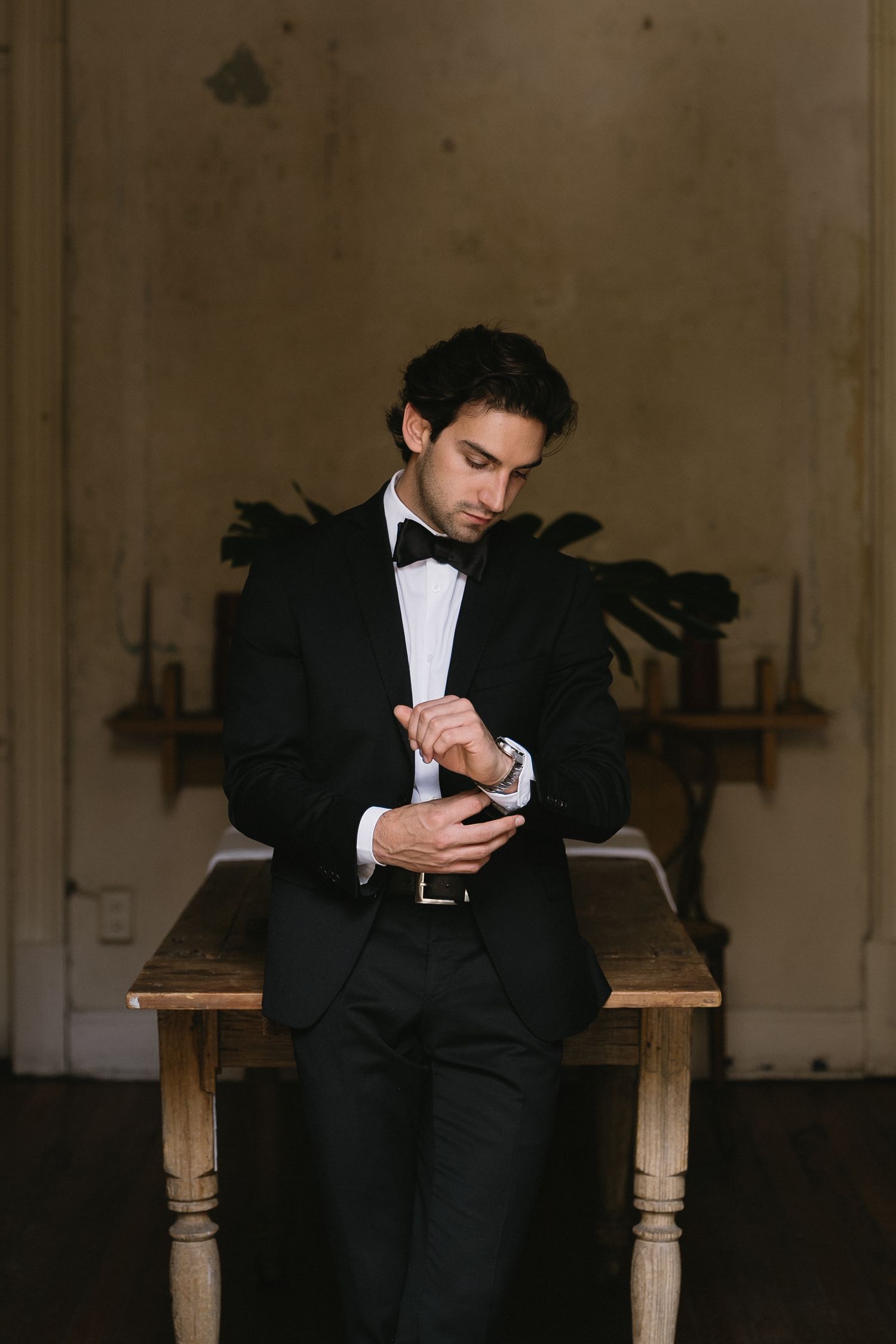 A series of artistic black and white photos showing a groom seated on a wooden bench.