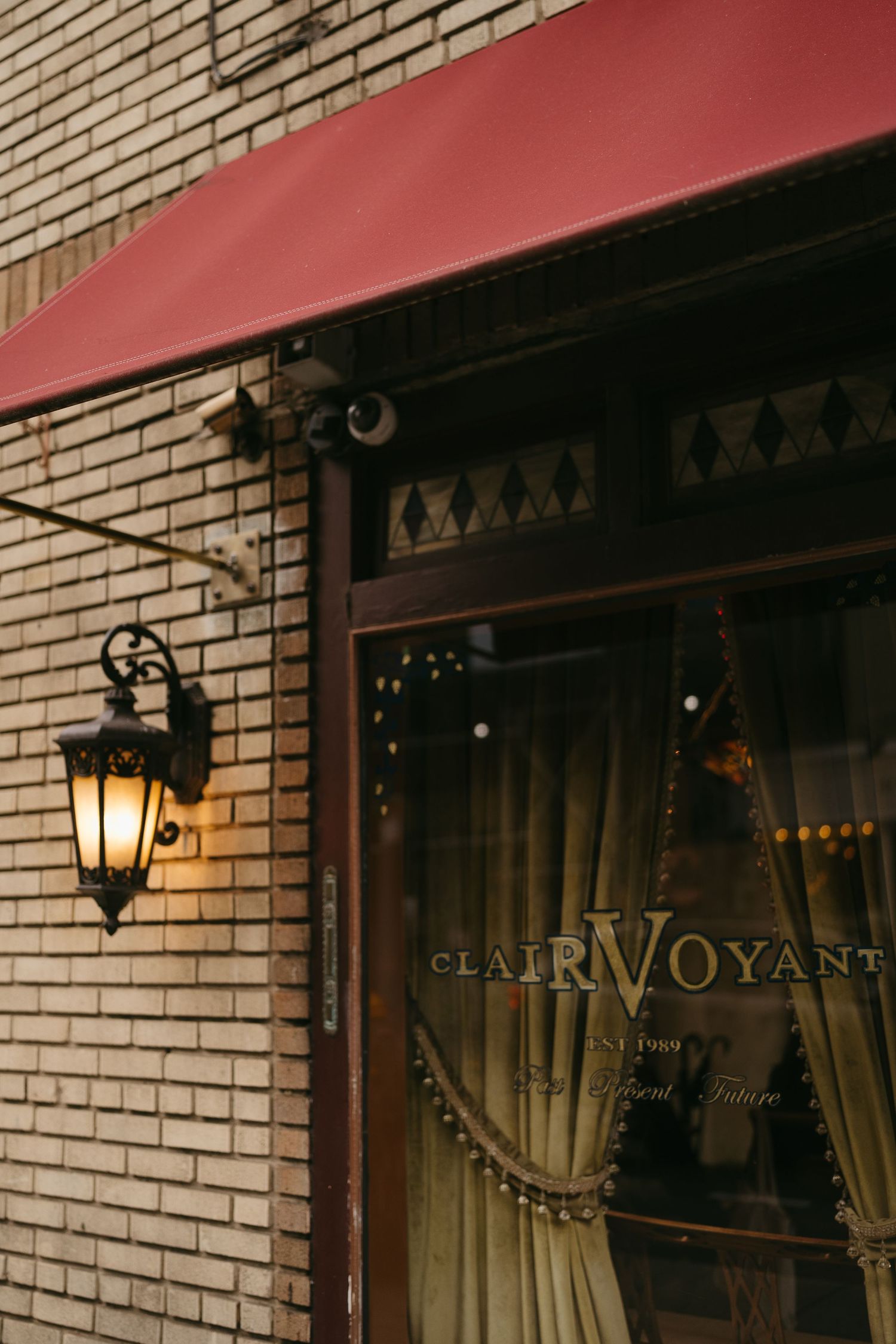 Exterior view of Clairvoyant restaurant with brick facade and wall-mounted lantern.