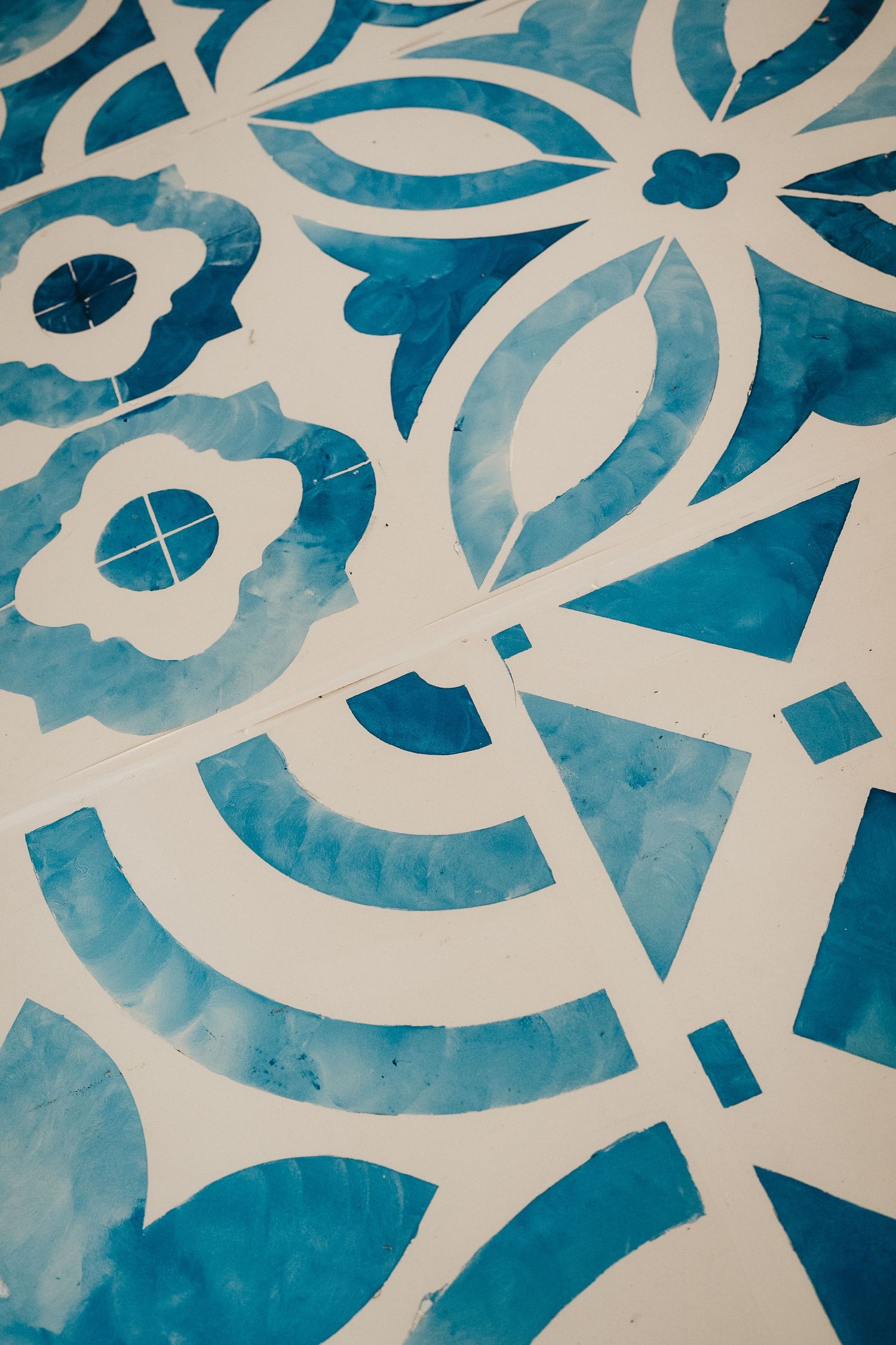 Abstract blue and white floral pattern design with watercolor texture and geometric shapes.