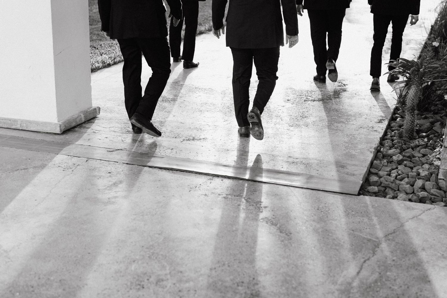 Silhouettes of people walking in a modern hallway with natural light.