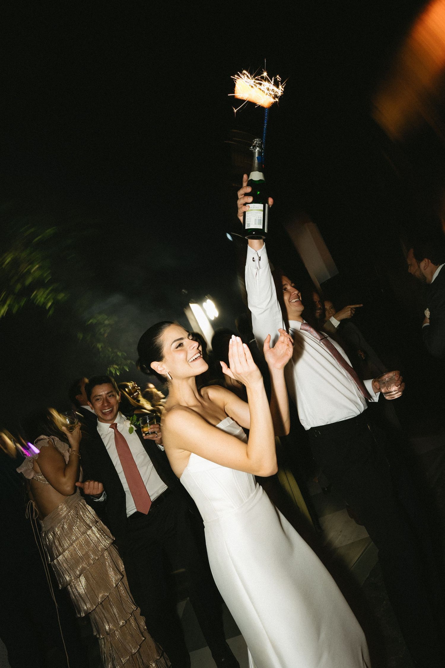 Candid nighttime reception photos showing guests dancing and celebrating.