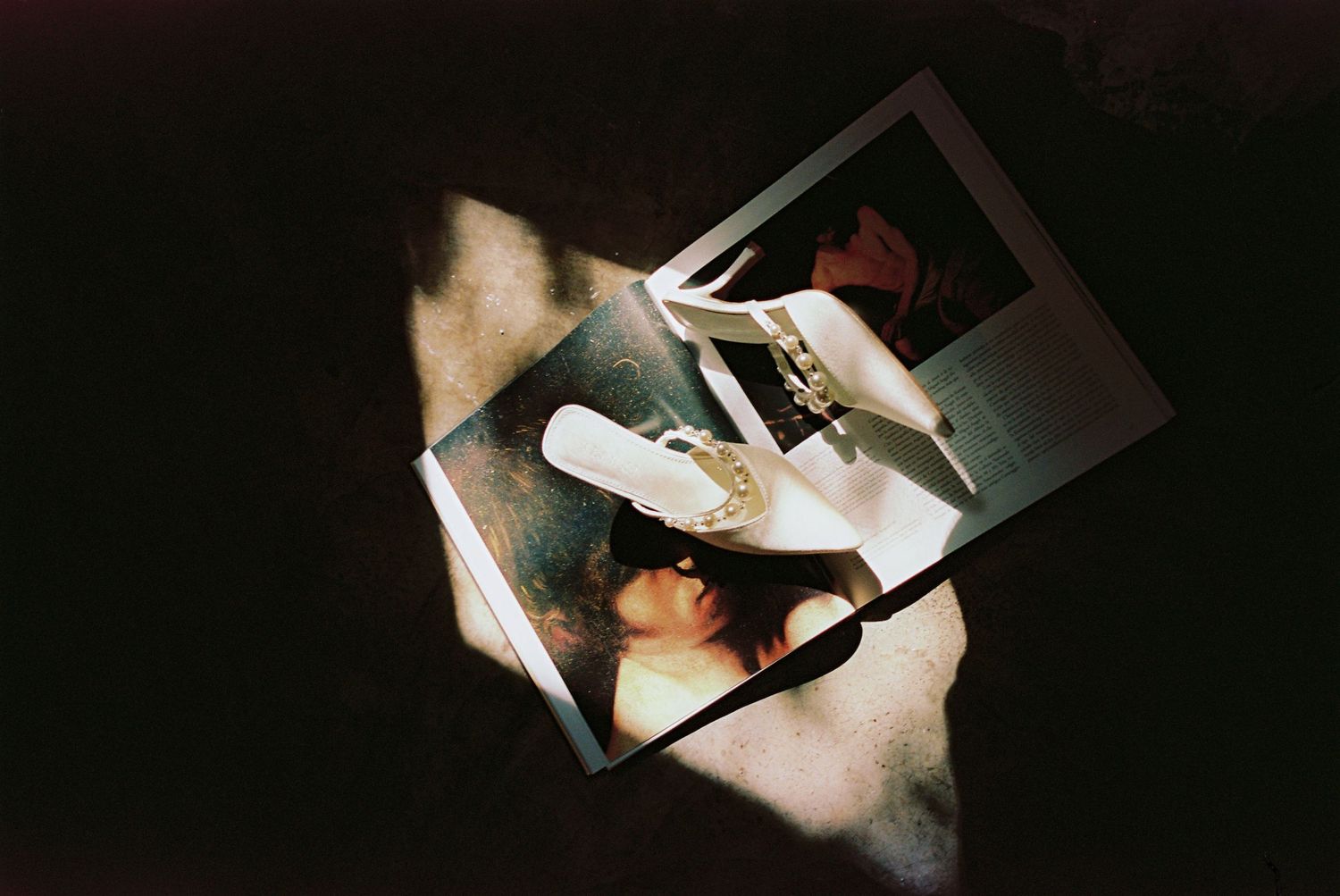 A person holding a white electronic device in a dimly lit setting with multiple similar photos arranged in sequence.