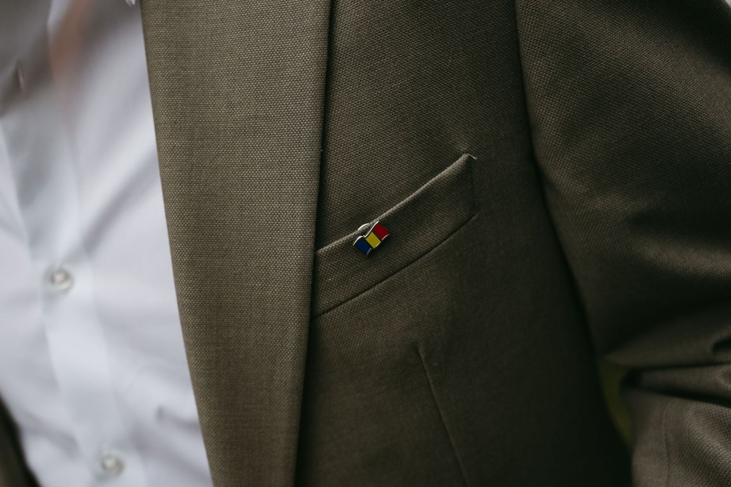 Close-up detail of a gray suit jacket worn at a formal wedding event.