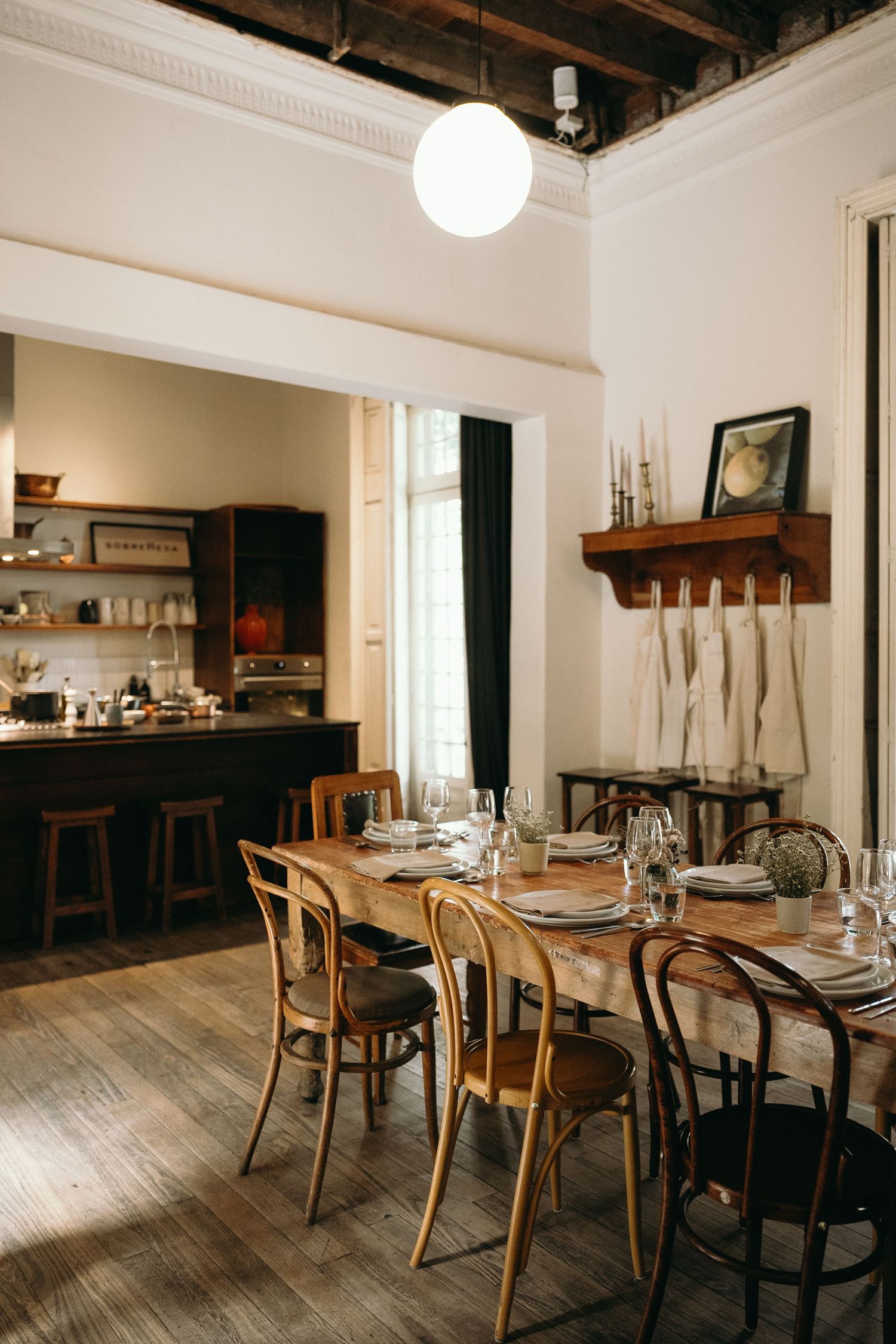 Vintage dining room with wooden chairs and exposed ceiling beams.