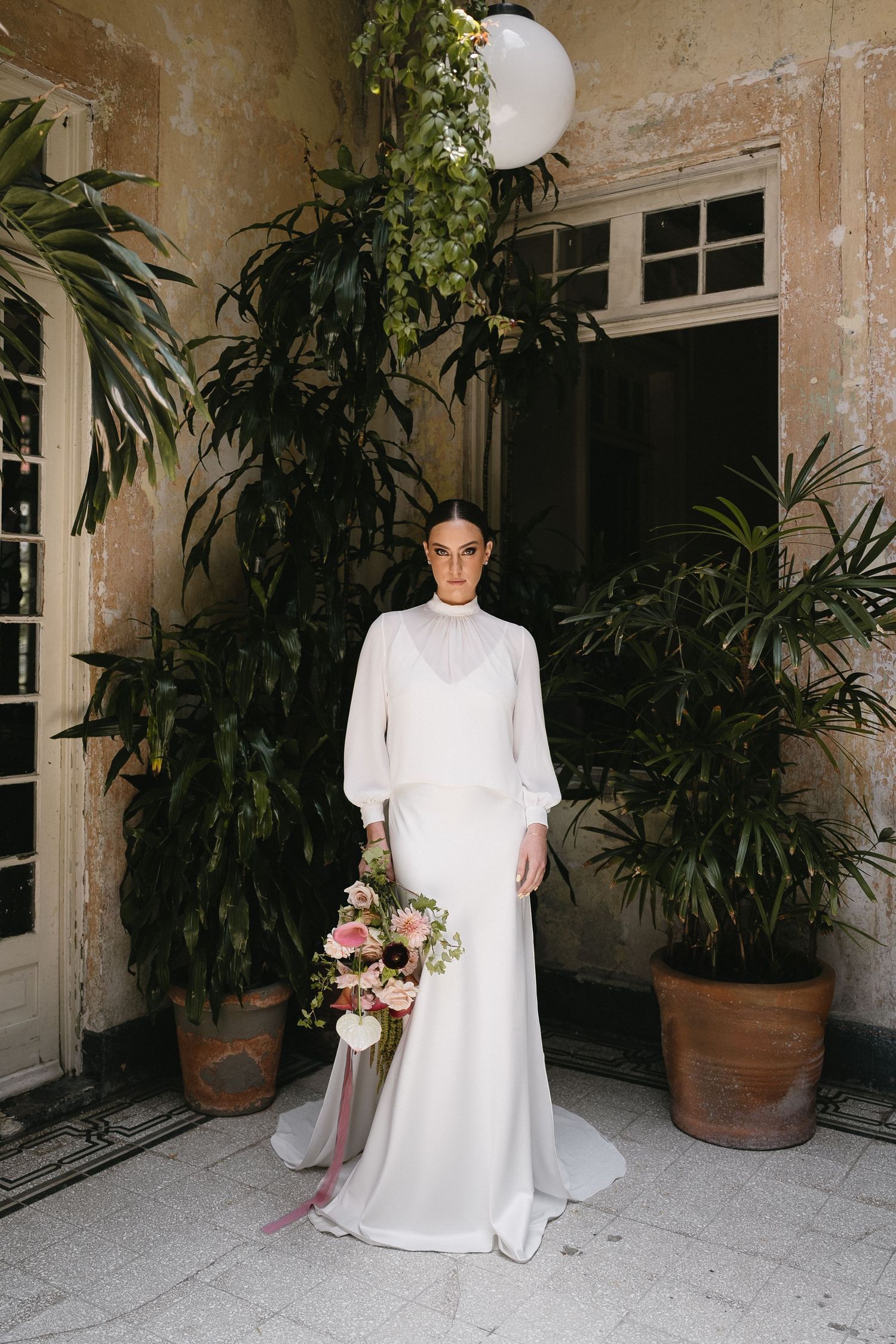 Elegant white wedding gown photographed in sequence against a rustic stone wall with potted plants.