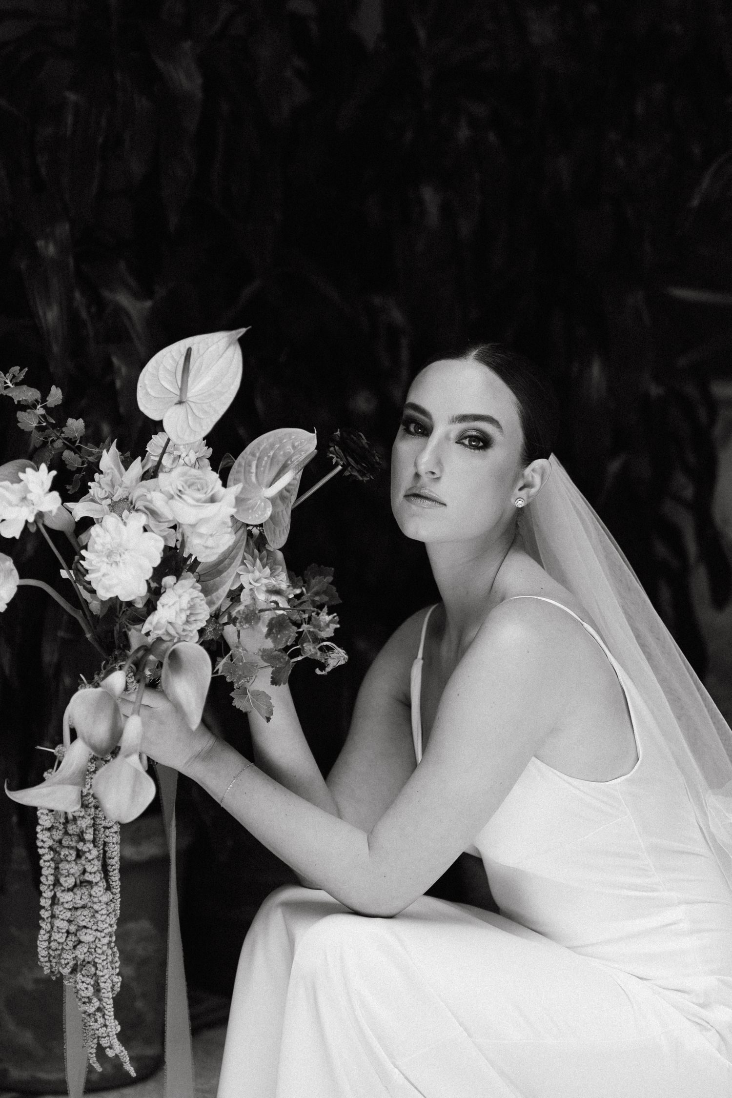 Black and white portrait with elegant floral arrangements and dramatic lighting.