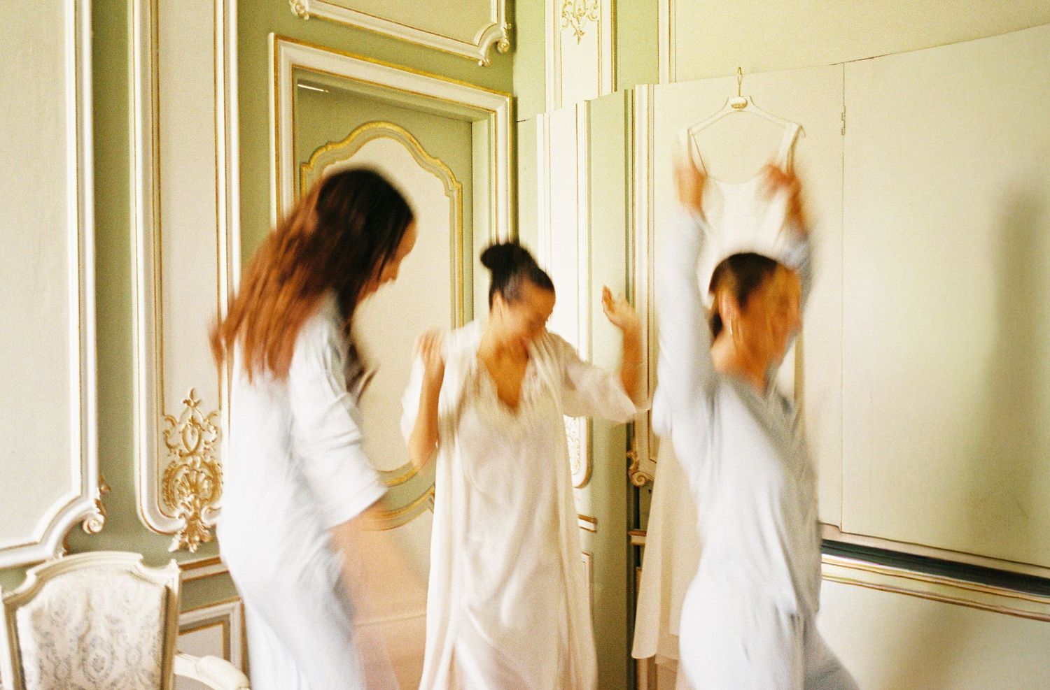 A series of motion blur photos showing a person in white clothing moving and dancing in a hallway.