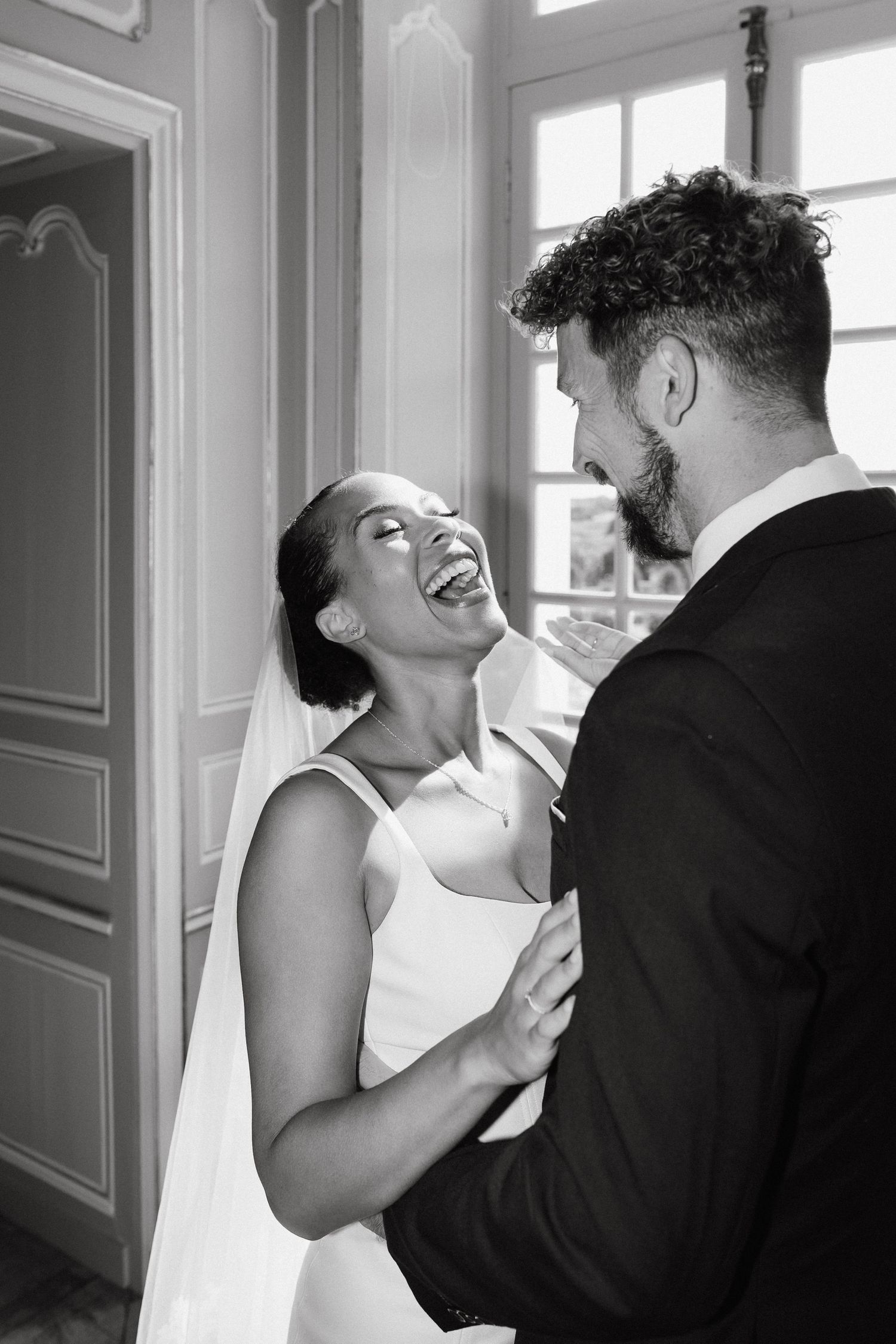 A sequence of candid black and white photos showing a joyful dancing moment indoors.