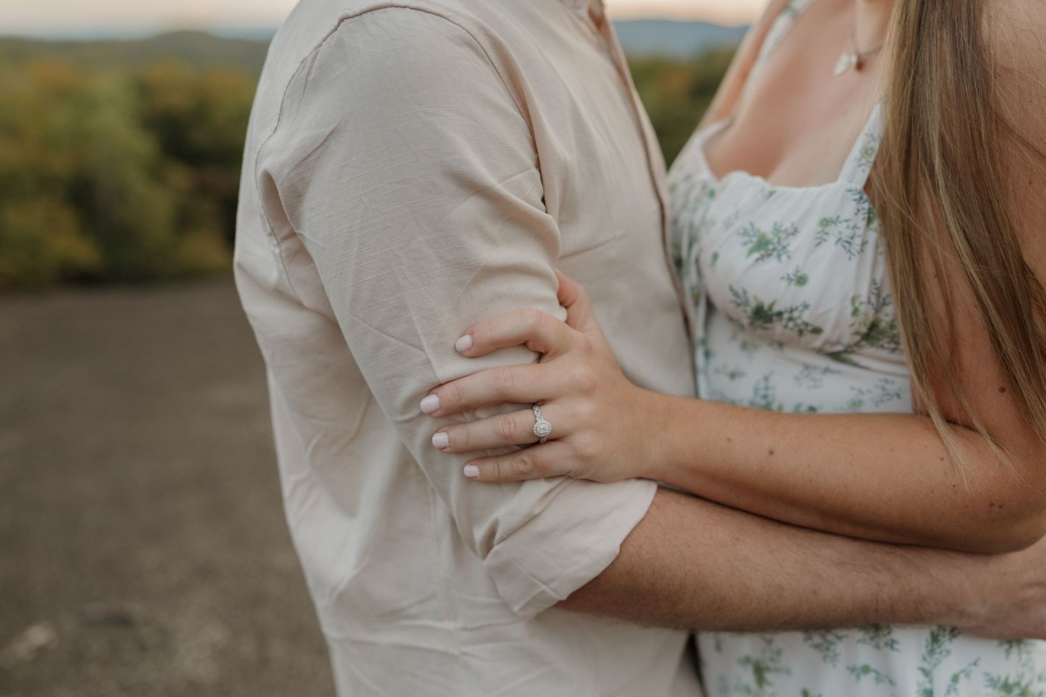 Romantic couple embracing during outdoor photoshoot with natural lighting.