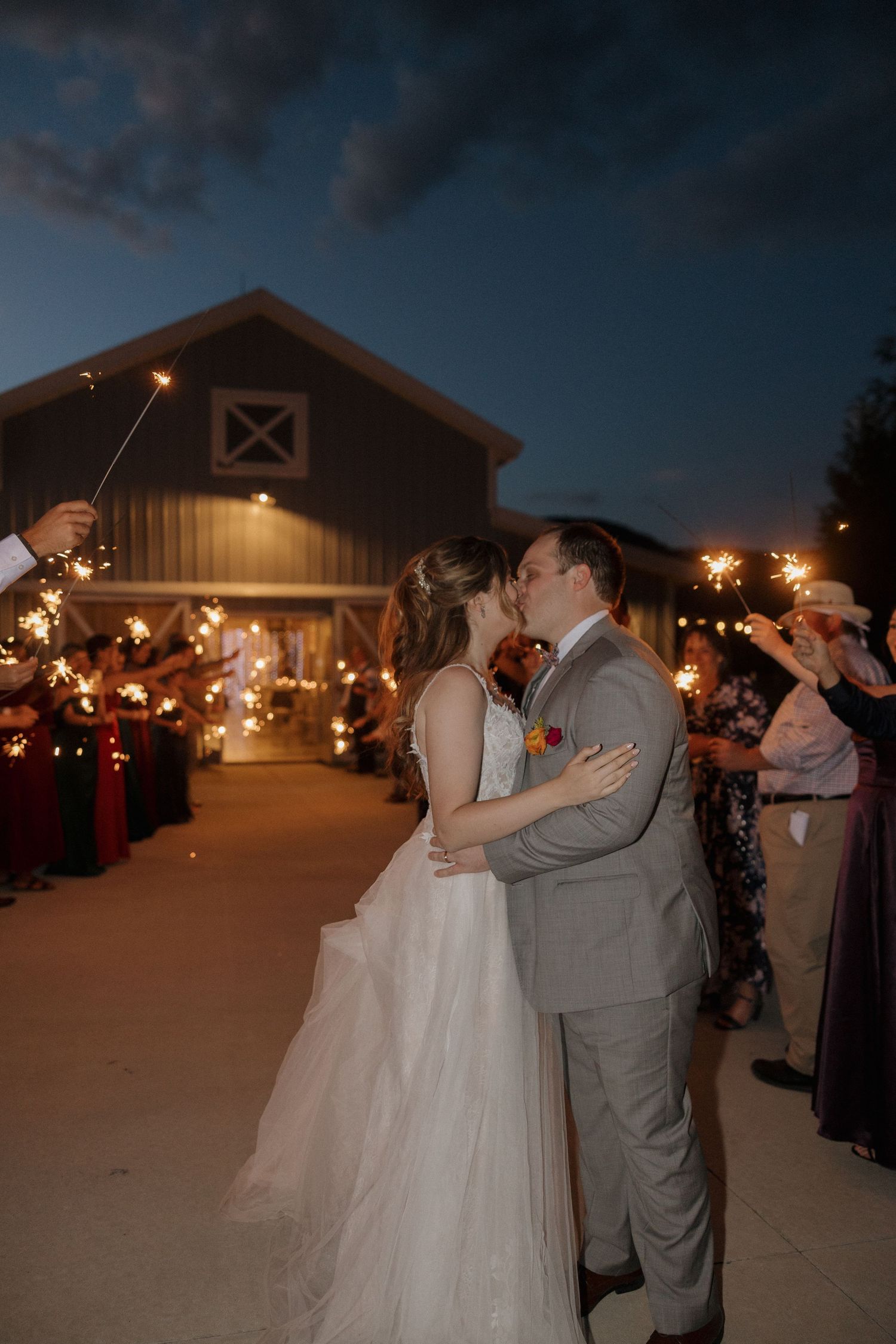 Romantic evening dance at a barn venue with string lights creating a warm ambiance.