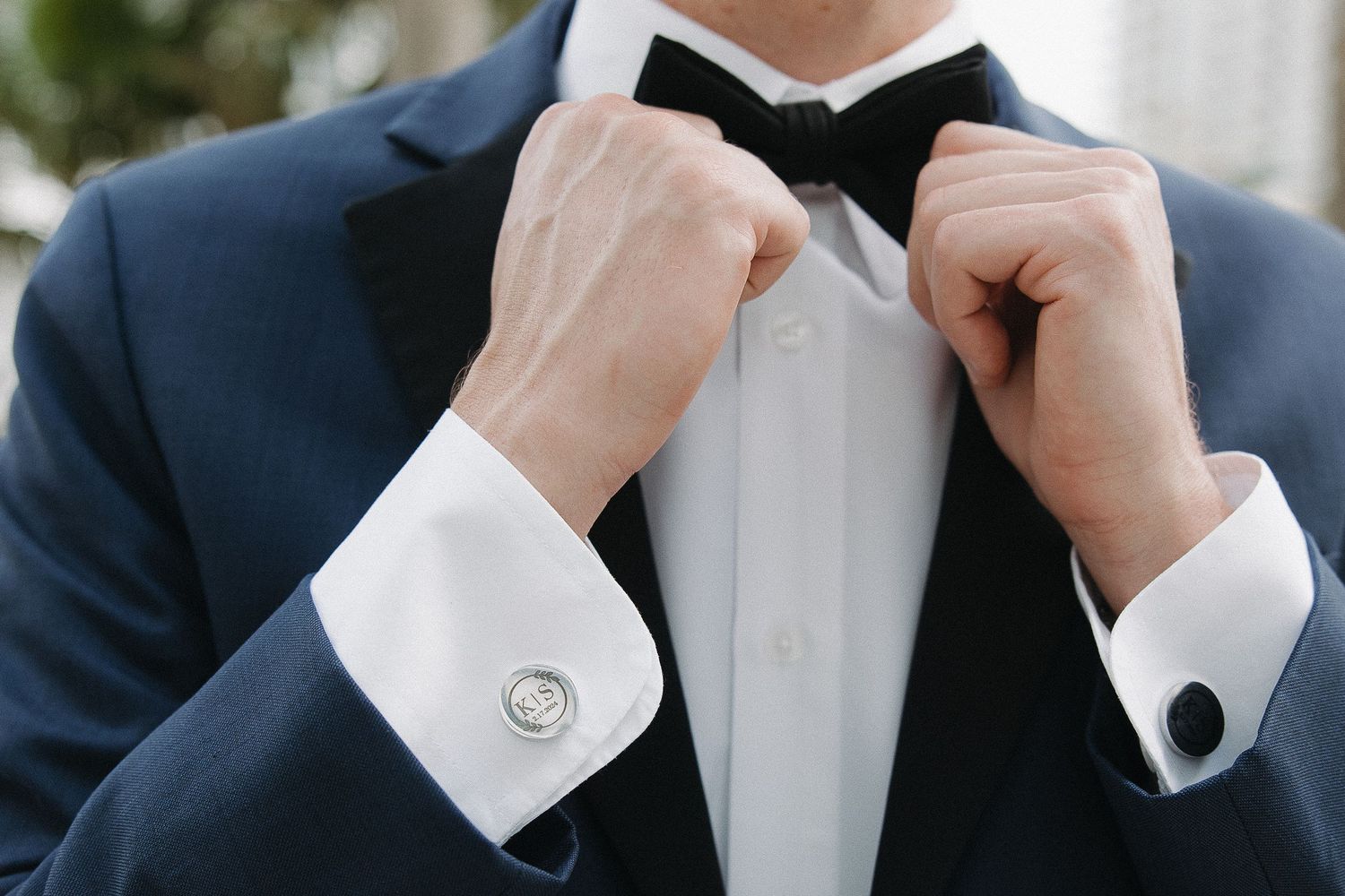 Close-up detail of a black bow tie and white dress shirt collar.