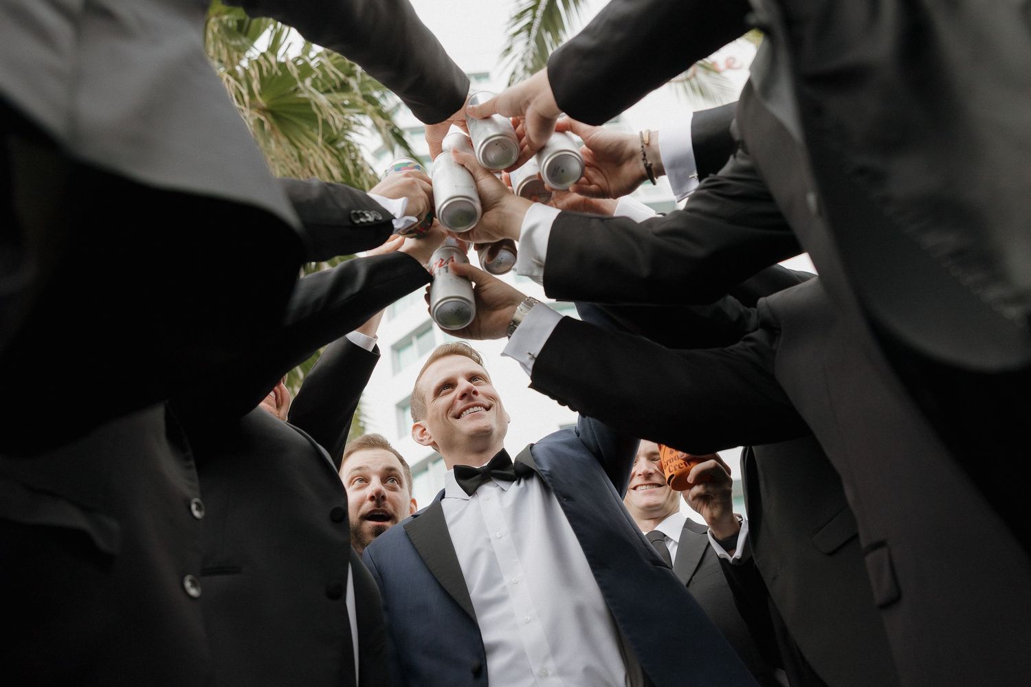 Groomsmen huddle together in black tuxedos for a group photo.