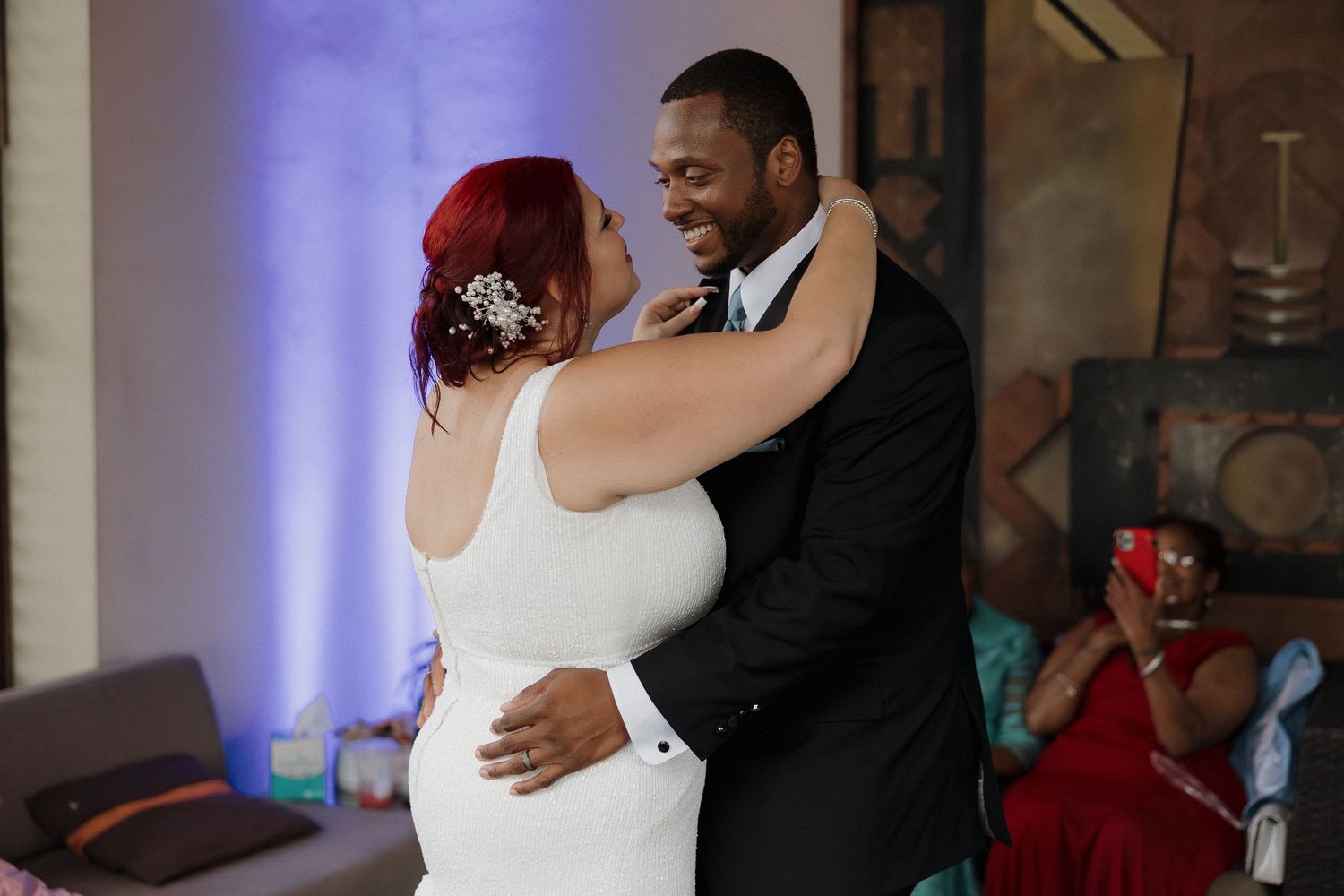 Wedding couple sharing first dance at indoor reception venue.