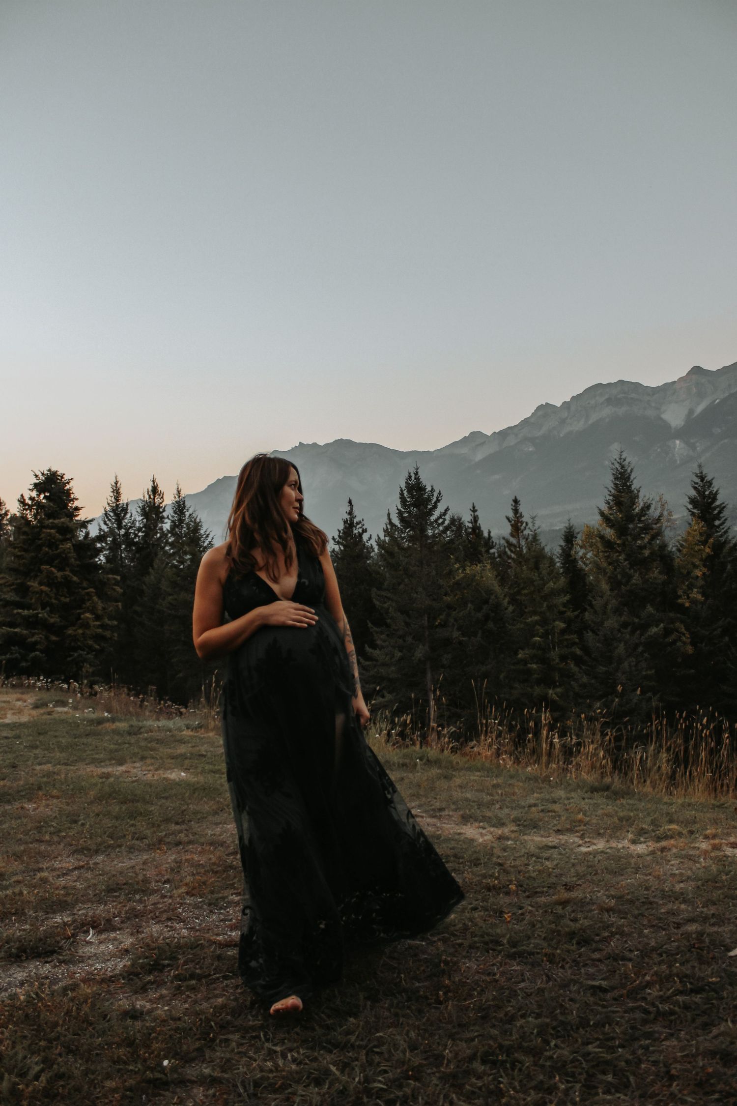 Silhouettes pose dramatically against mountain landscape at dusk.