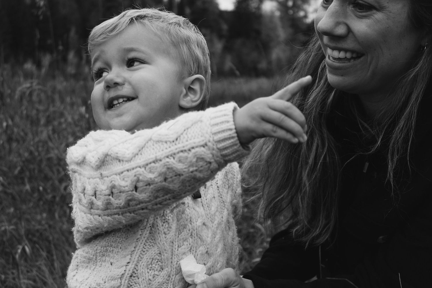 Black and white candid moment showing joy and laughter against a mountain backdrop.