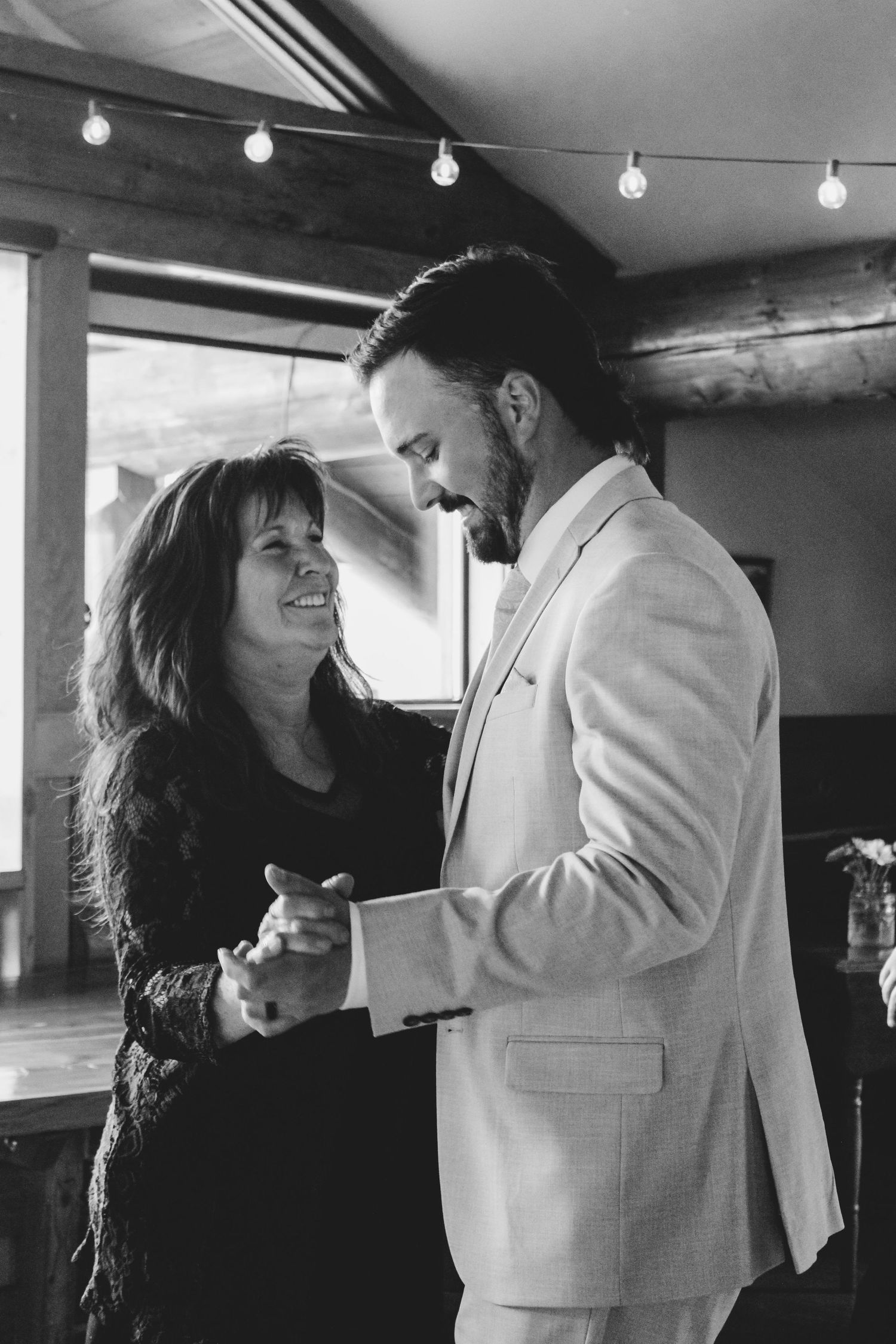 Black and white photo showing a couple dancing and laughing together during a joyful moment.