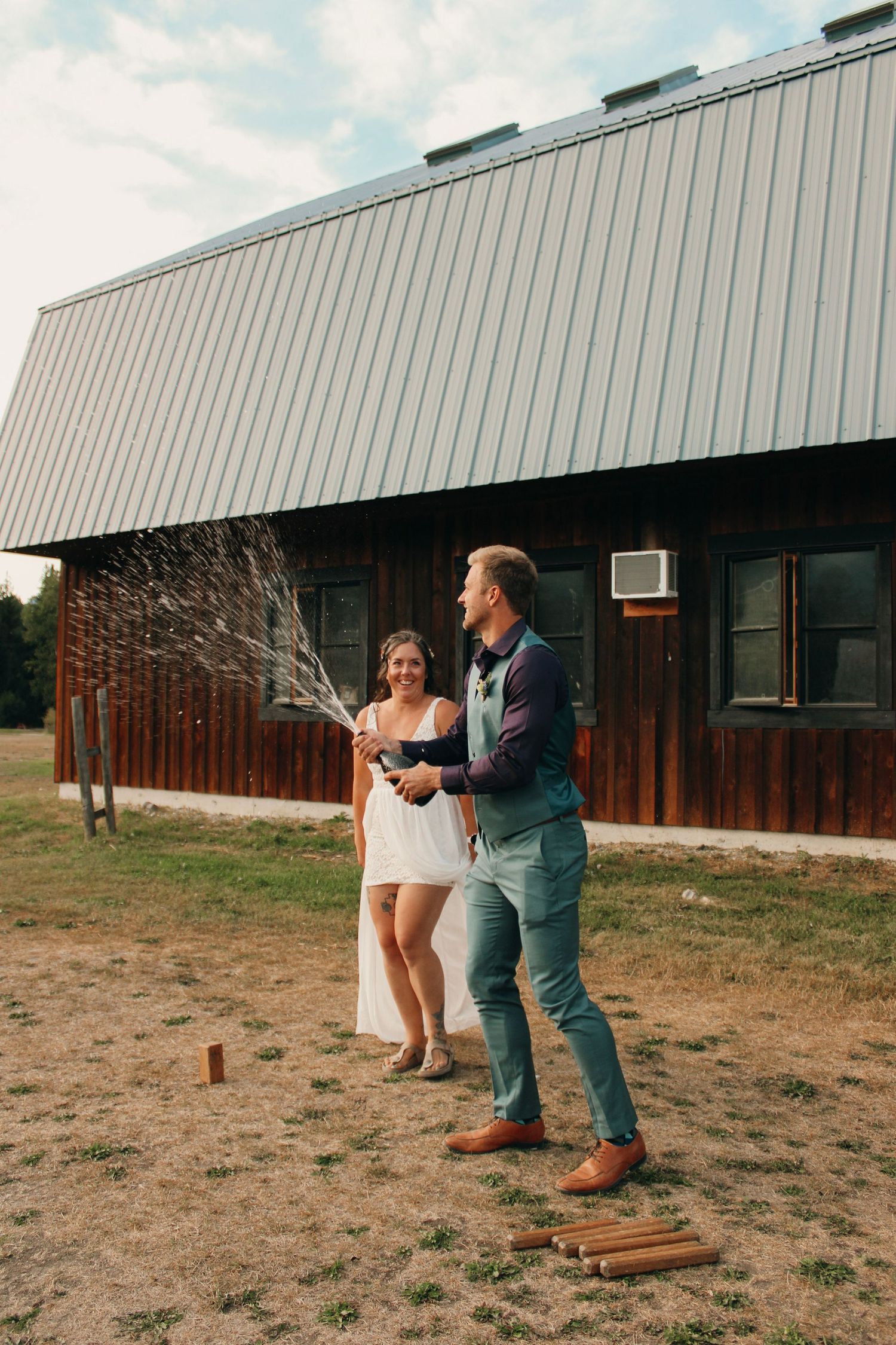 Playful sequence of a couple having fun outside a modern barn building during a wedding photoshoot.