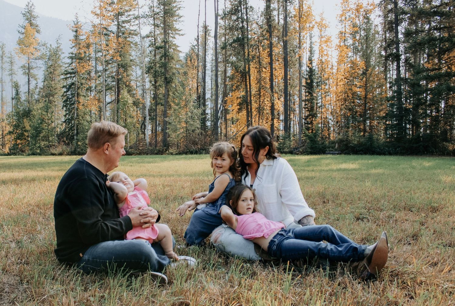 A series of candid family moments captured in a golden forest meadow during autumn.