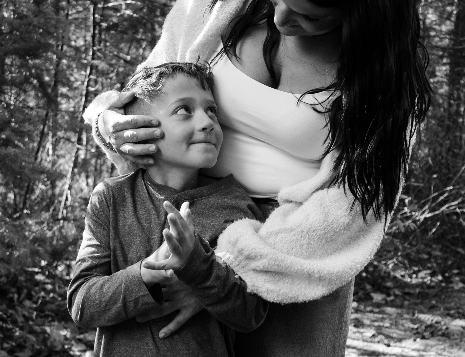 An intimate family portrait session captured in a wooded outdoor setting.