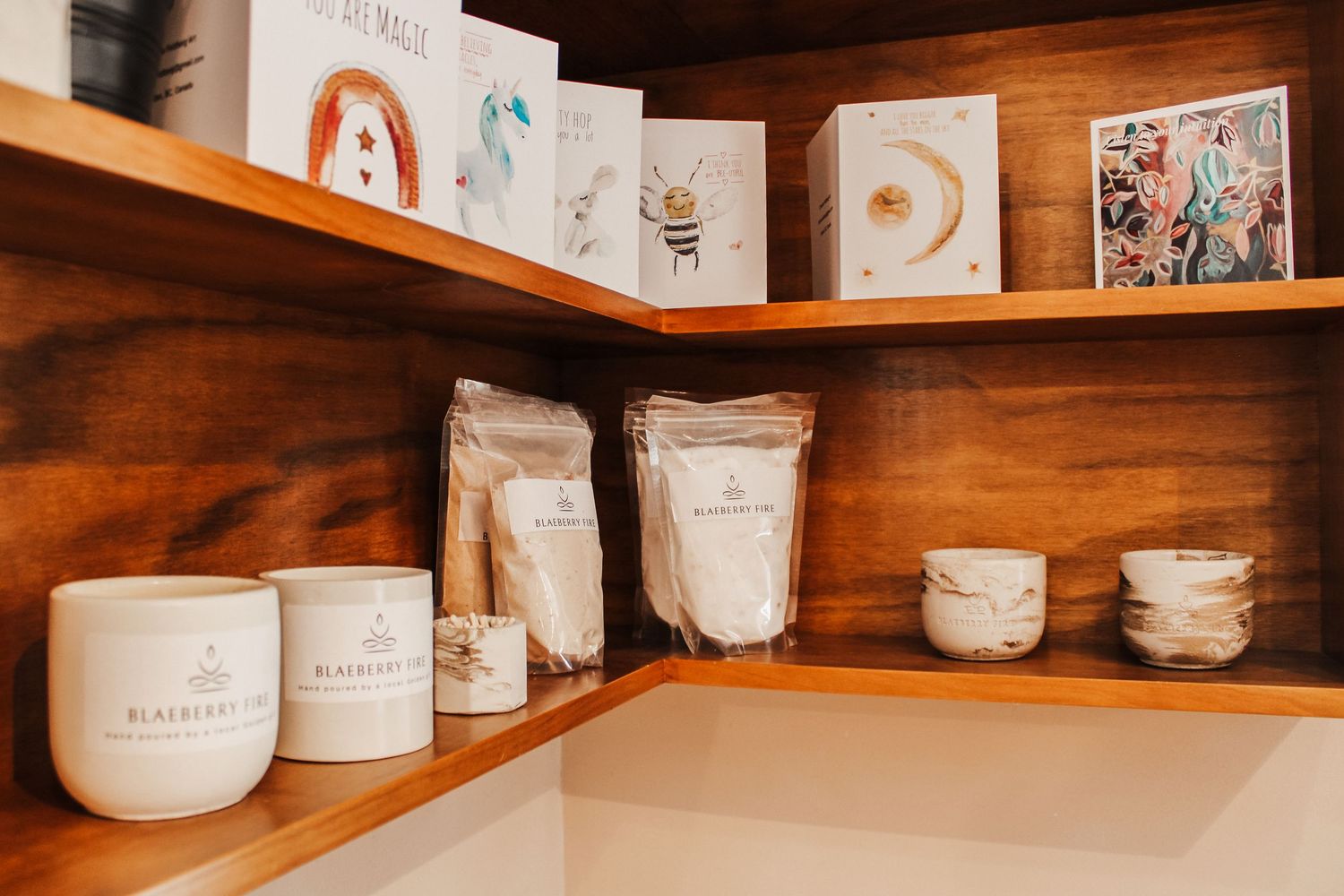 Wooden shelves displaying a collection of white ceramic pottery and kitchenware in a rustic retail setting.
