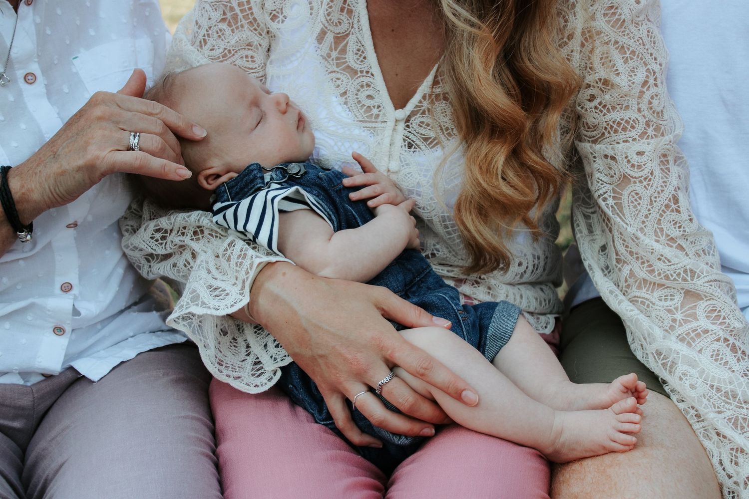 An intimate family moment captured on a white background with delicate lace details.