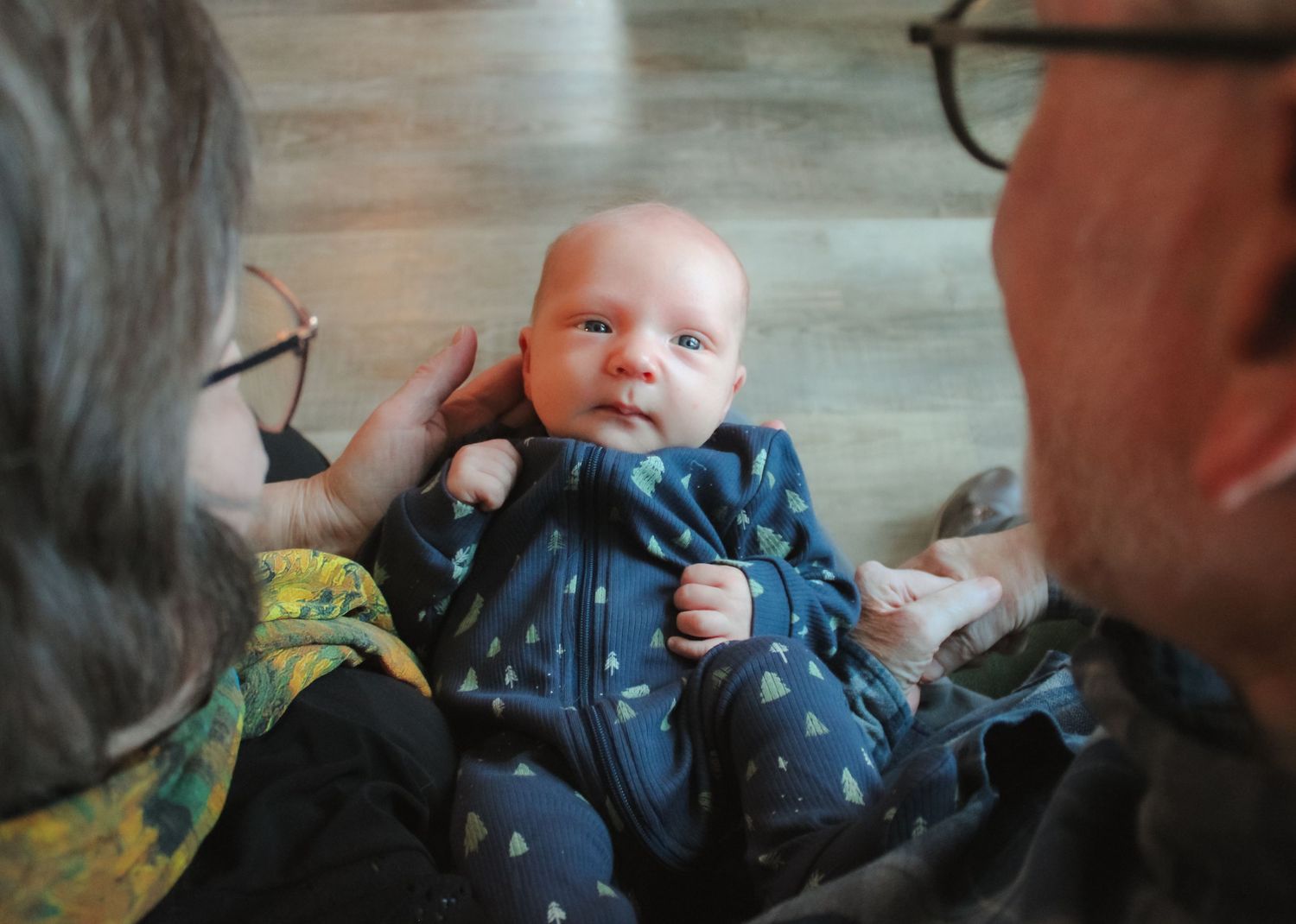 Family shares tender moments together indoors while relaxing on furniture.