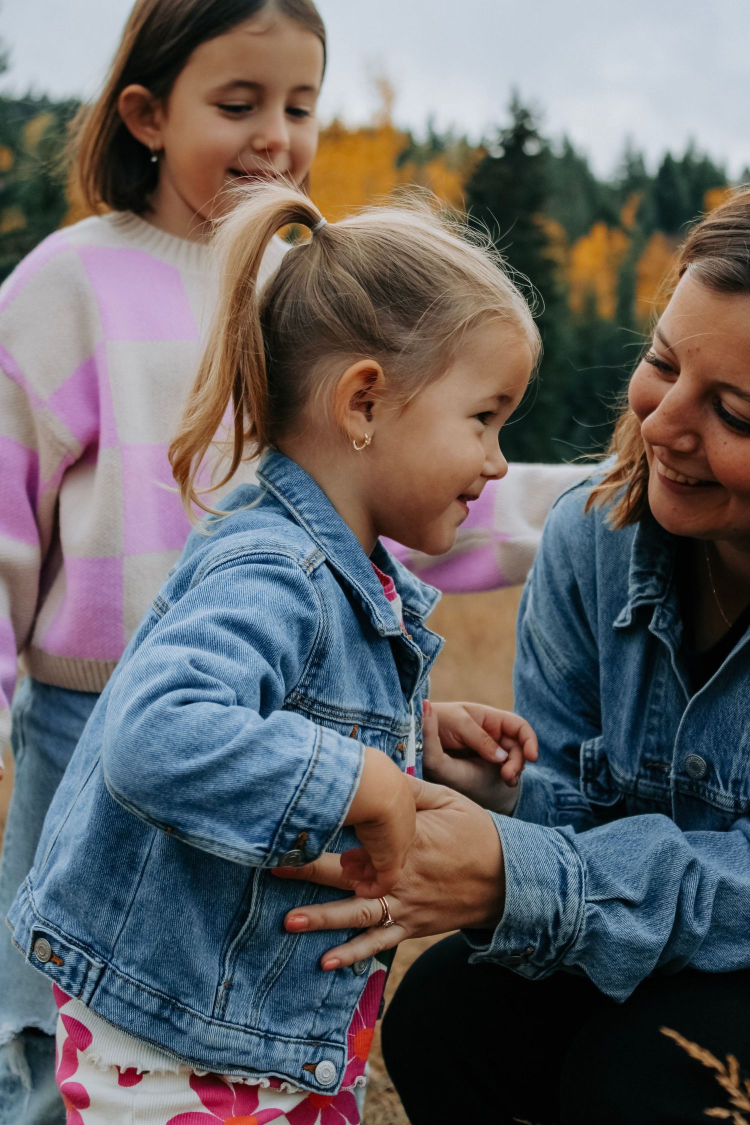 Tender moments shared while wearing denim jackets against an autumn backdrop.