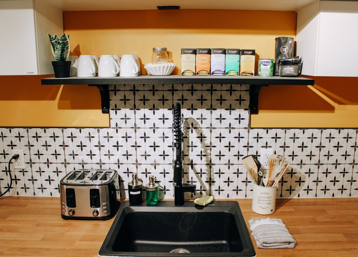 Modern kitchen backsplash featuring black and white cross pattern tiles with wooden countertops.