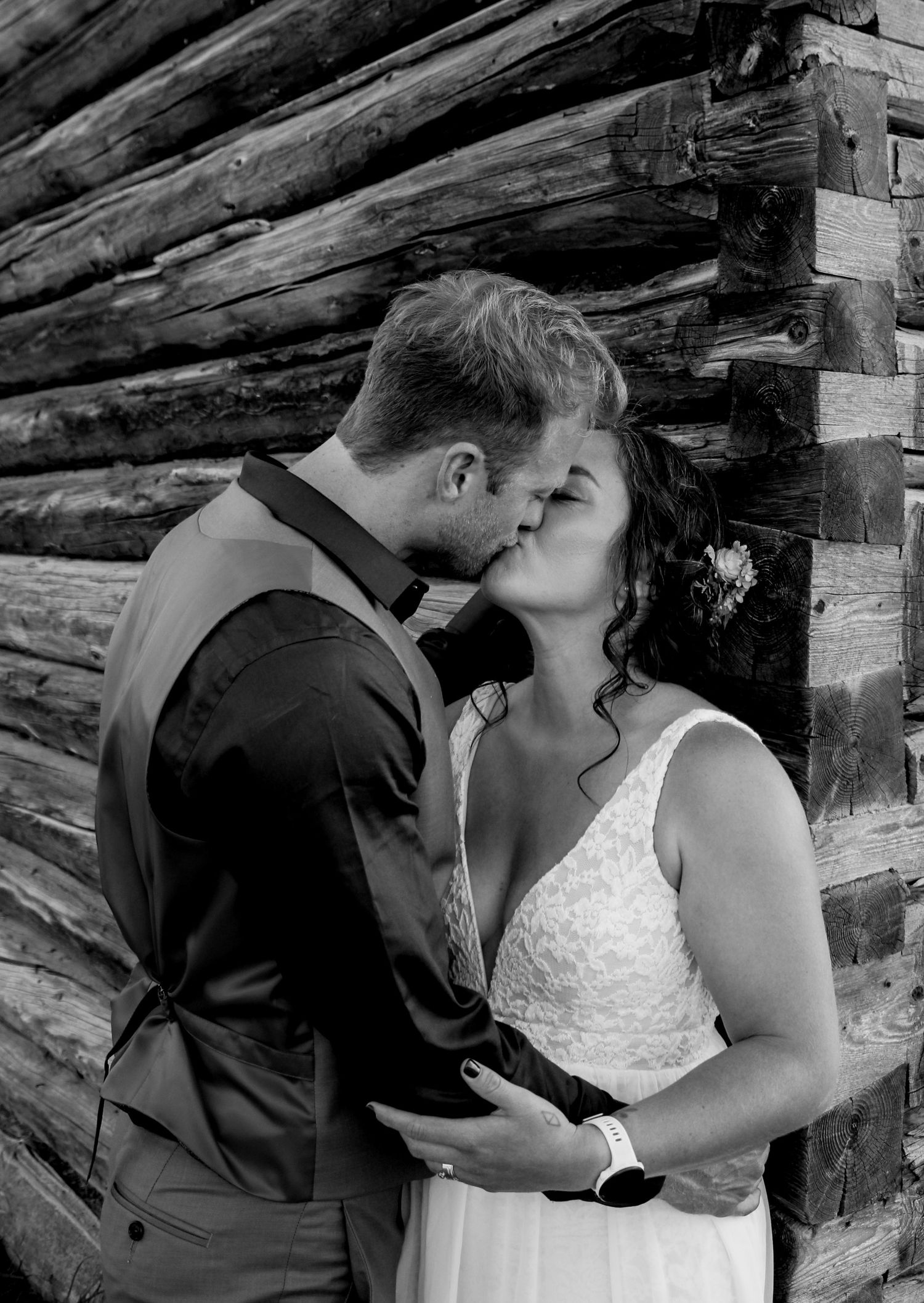 Black and white wedding photo series showing intimate moments between newlyweds near wooden beams.
