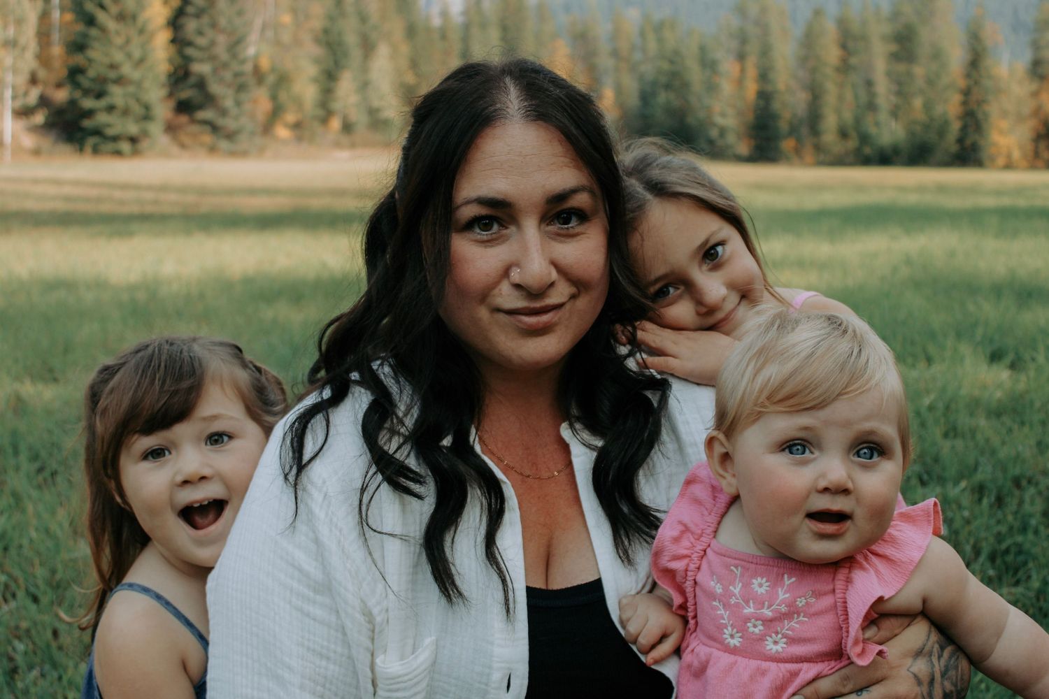 Candid family interactions photographed in a mountain meadow during golden hour.