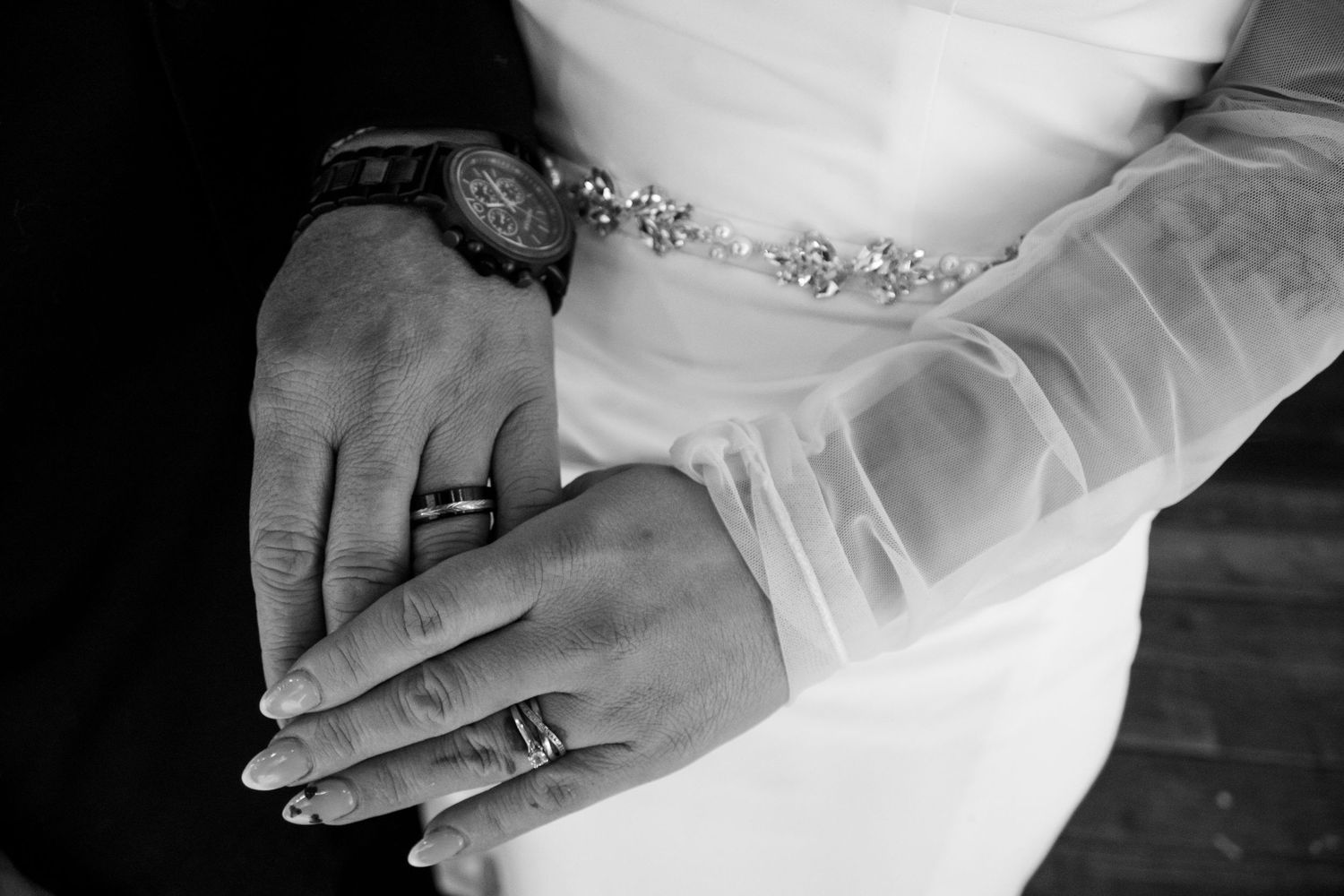 Wedding dress details showing delicate beadwork and fabric textures in monochrome photography.
