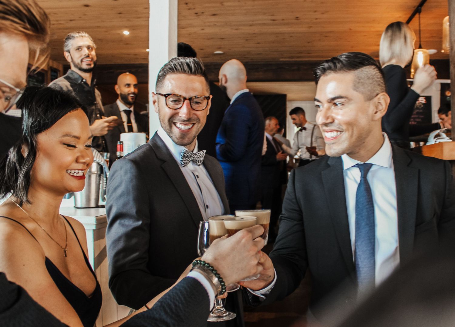 Three elegantly dressed professionals toasting with champagne glasses at a formal networking event.