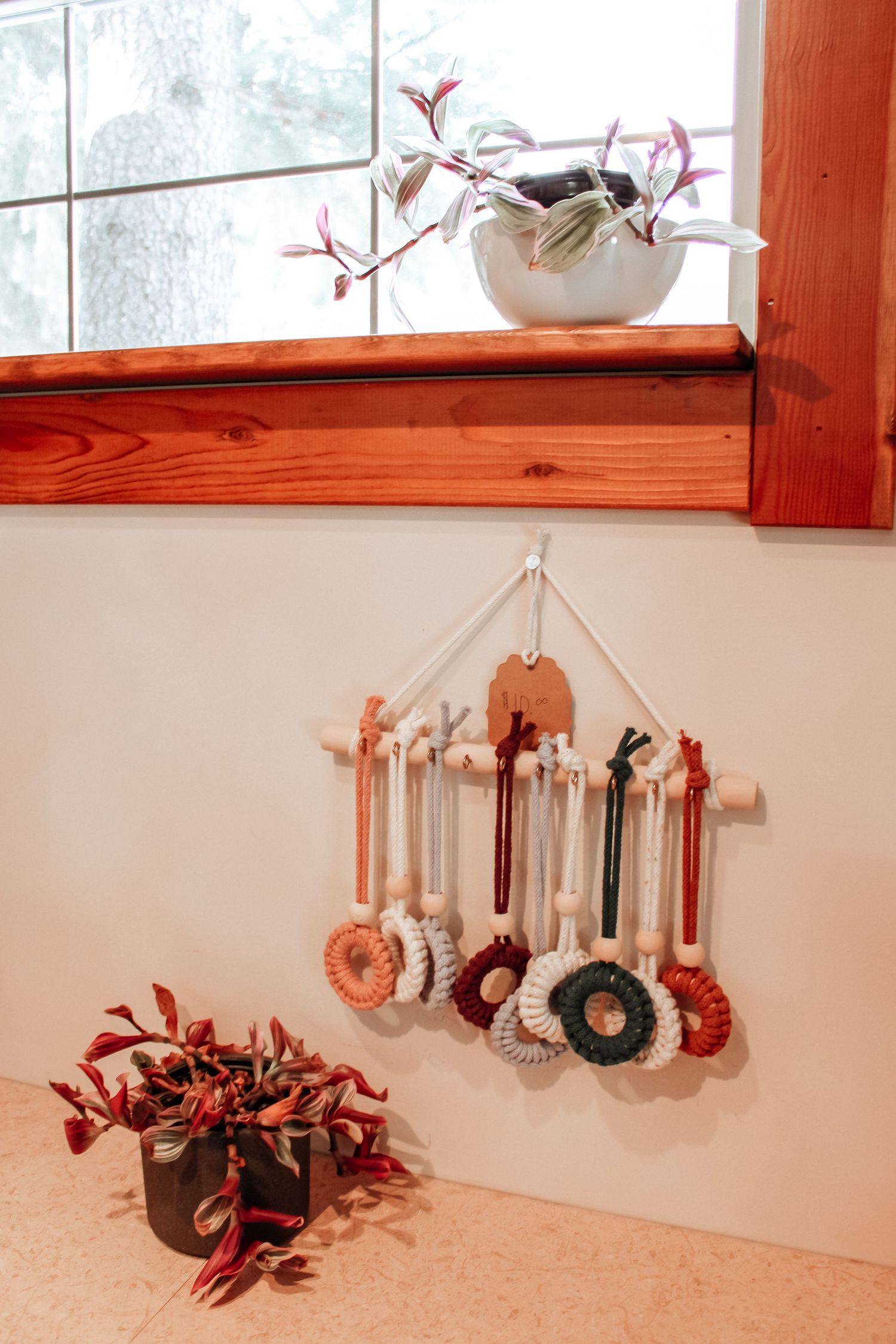 Decorative hanging letters in warm tones displayed near window with natural light.