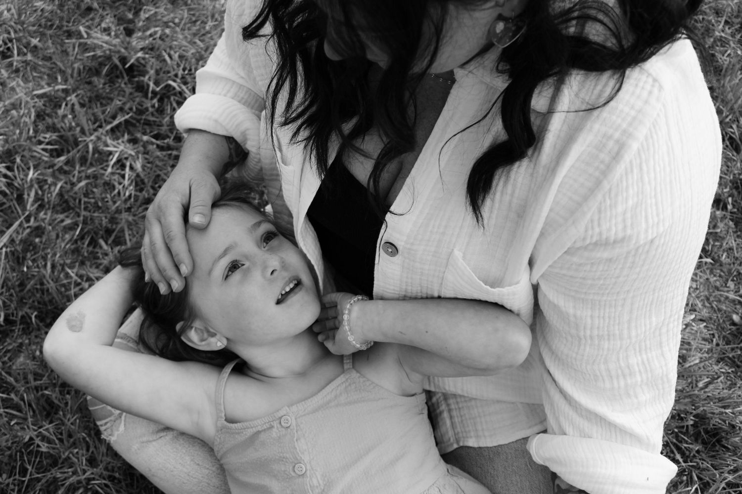 Black and white series capturing tender embraces and genuine laughter during an outdoor photo session.