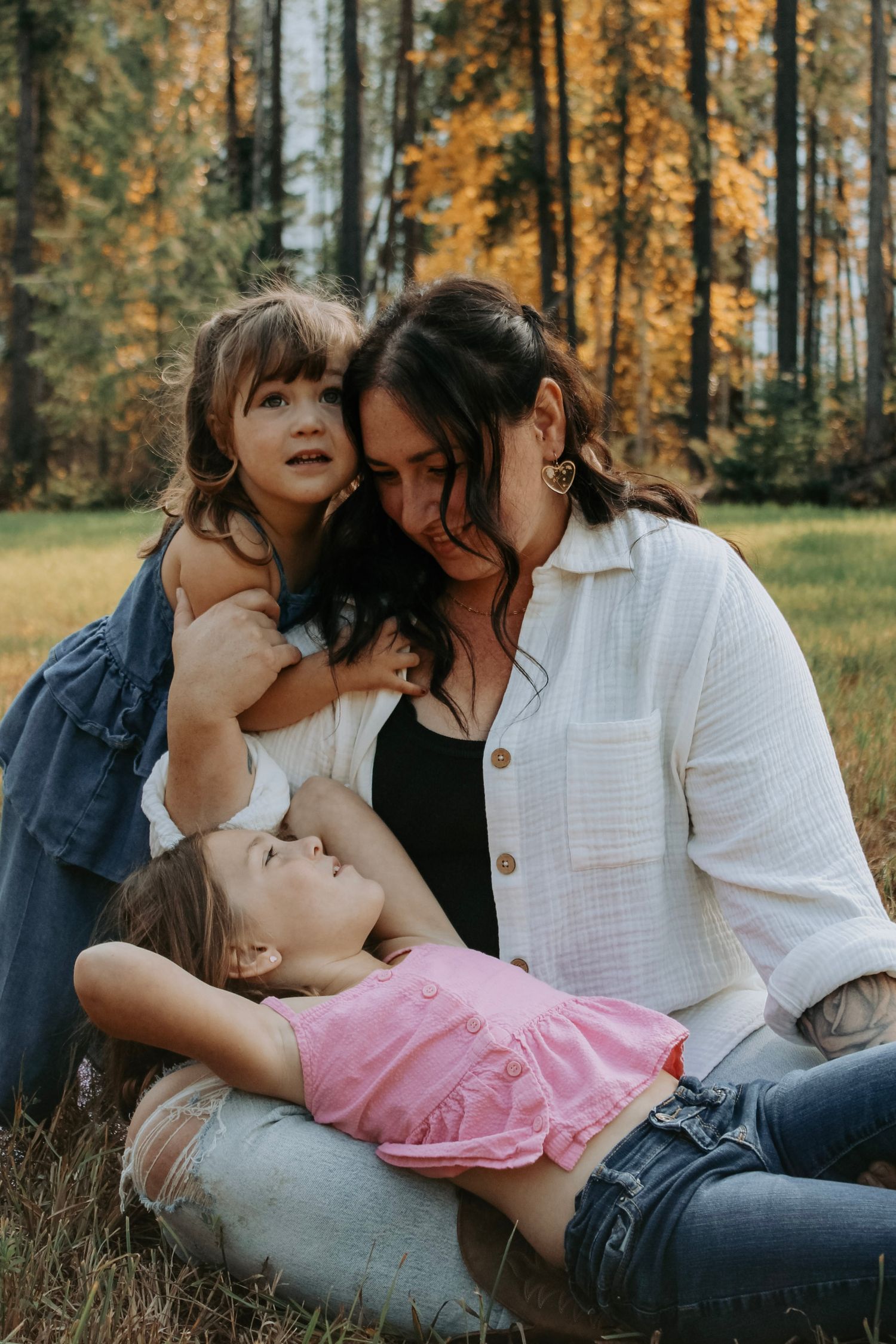 Candid family moment captured in a sun-dappled autumn forest.