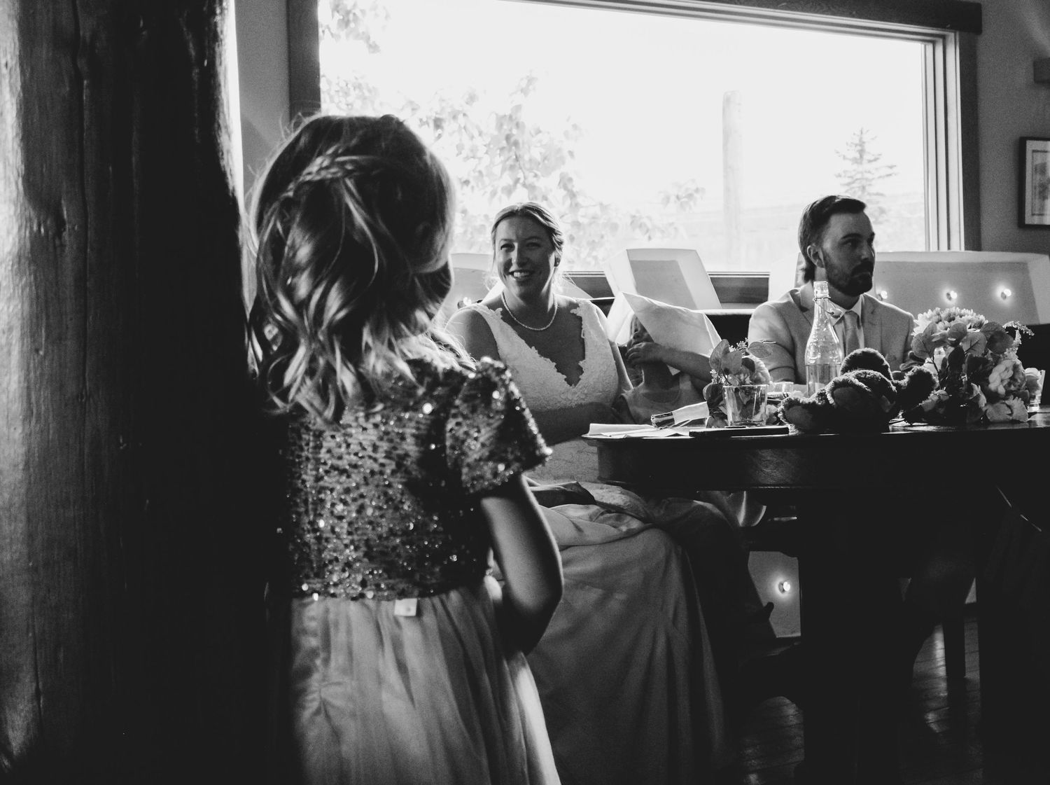 Black and white panoramic shot of a wedding reception venue with rustic wooden beams.
