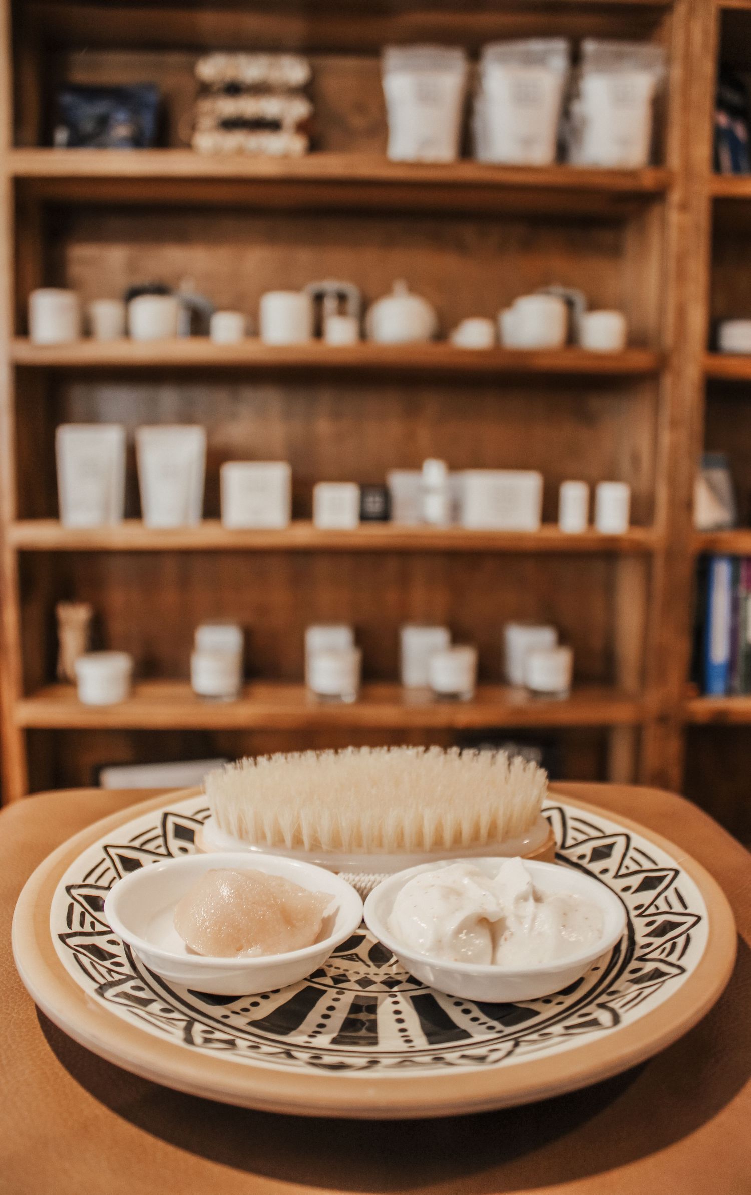 Black and white geometric patterned plates arranged on wooden display shelves.