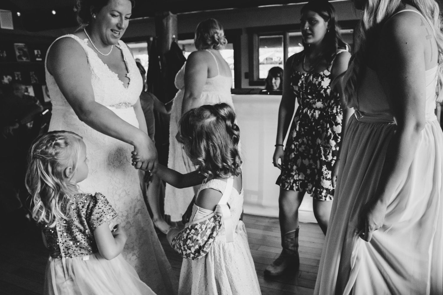 Candid black and white shots of wedding guests dancing and celebrating.