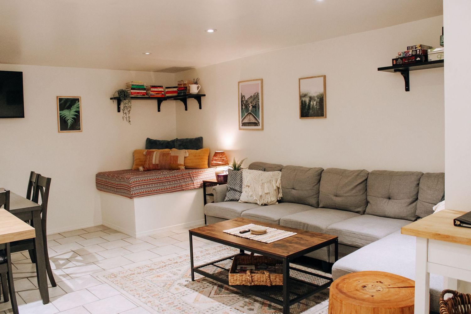 Modern minimalist living room interior with grey couch, wooden coffee table and floating shelves.