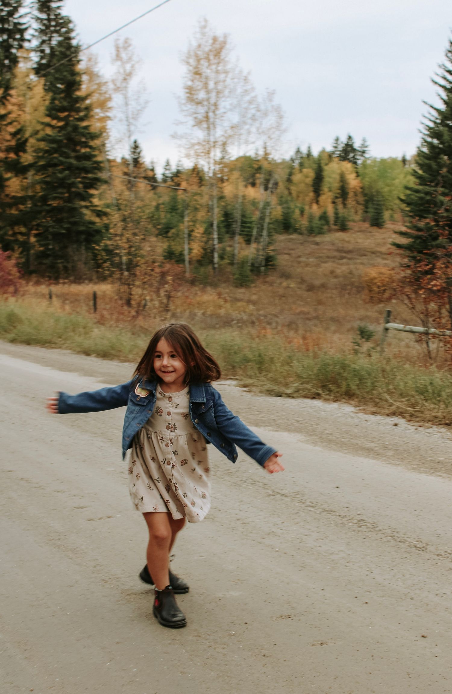 Playful movements captured on a dirt road with mountain scenery.