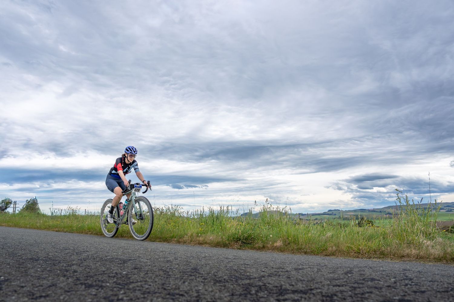 lone cyclist riding towards the finish of a race.