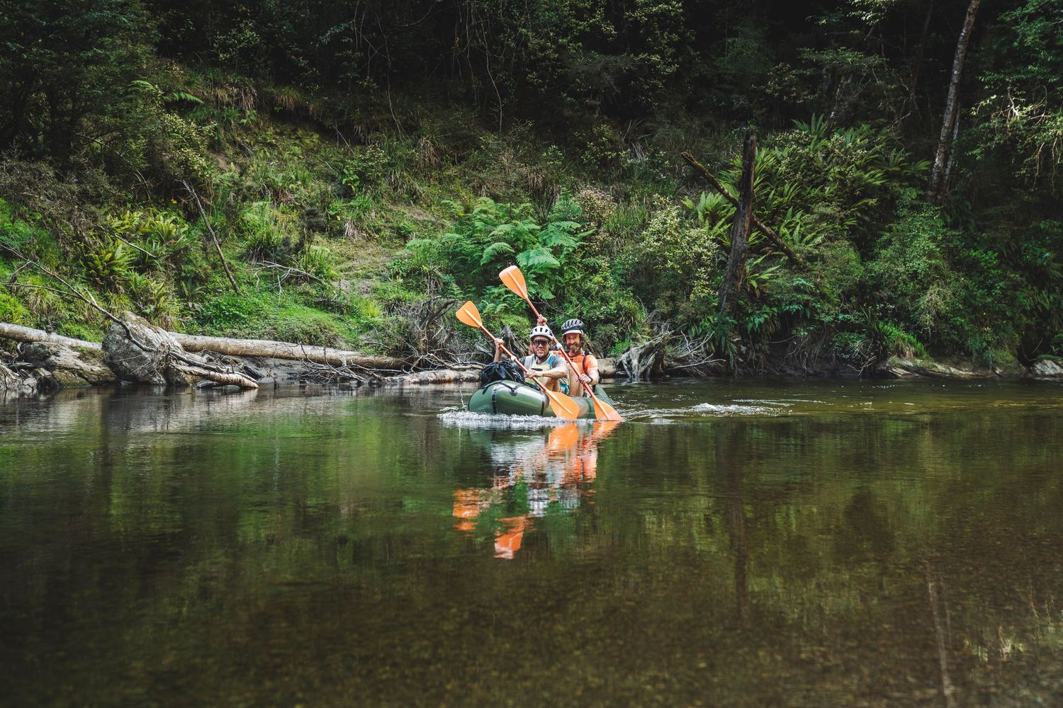 Pack Rafters paddling down a river. calm waters and reflections.