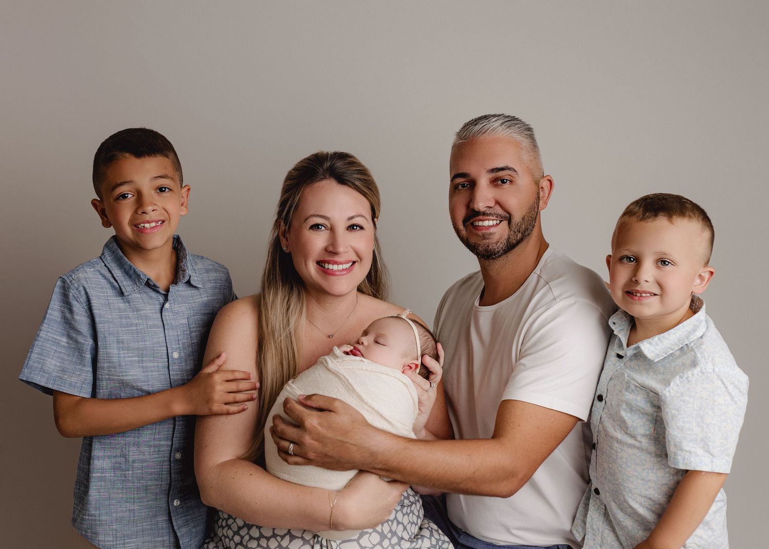 A series of four black and white family portraits showing tender moments between loved ones.