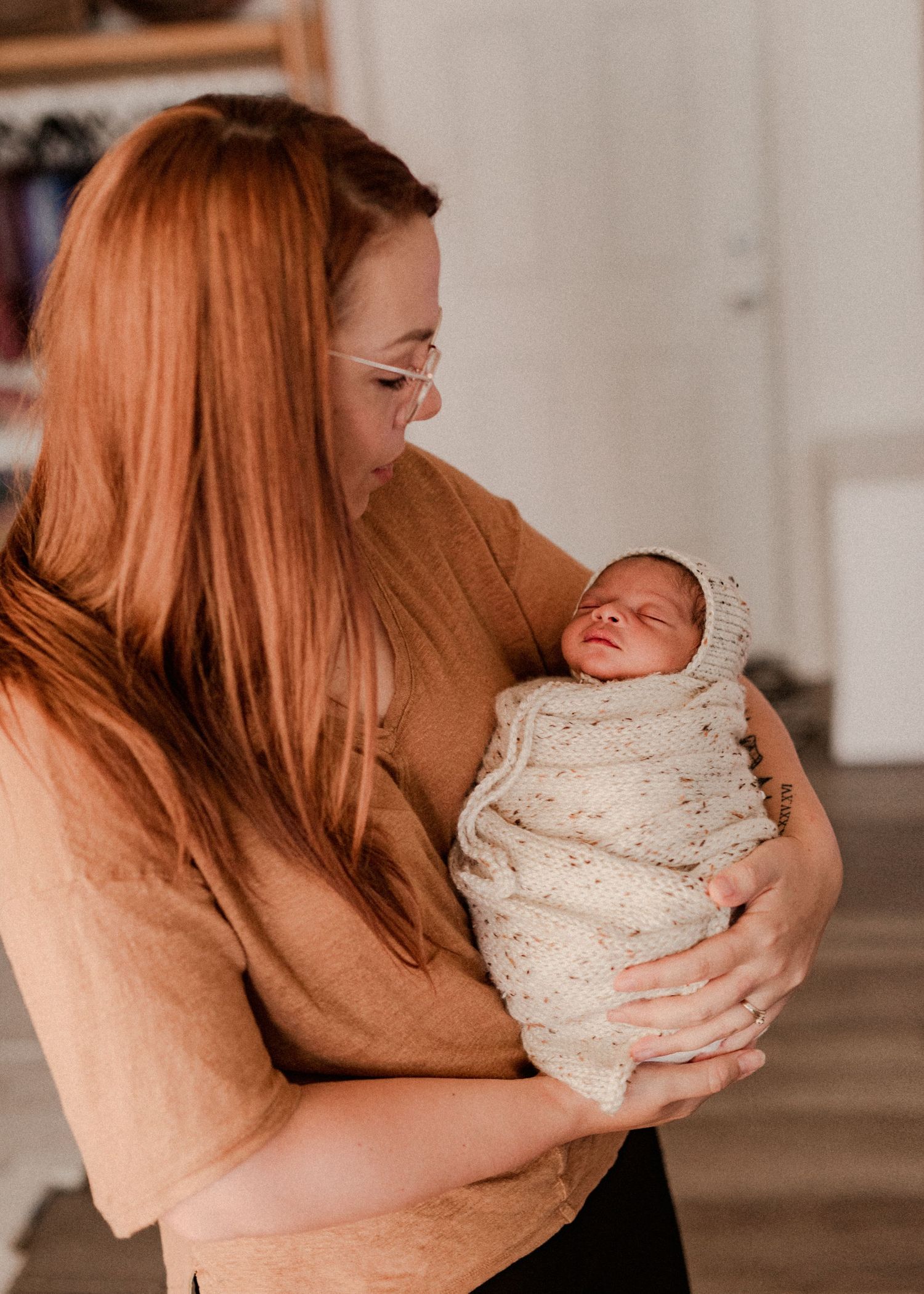 A tender moment between parent and newborn baby in a series of intimate photographs showing gentle embraces and care. baby in Oxford michiga